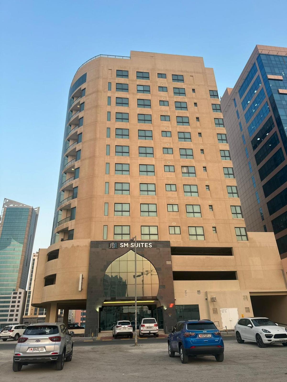 a large building with cars parked in a parking lot at seef manzil in Seef