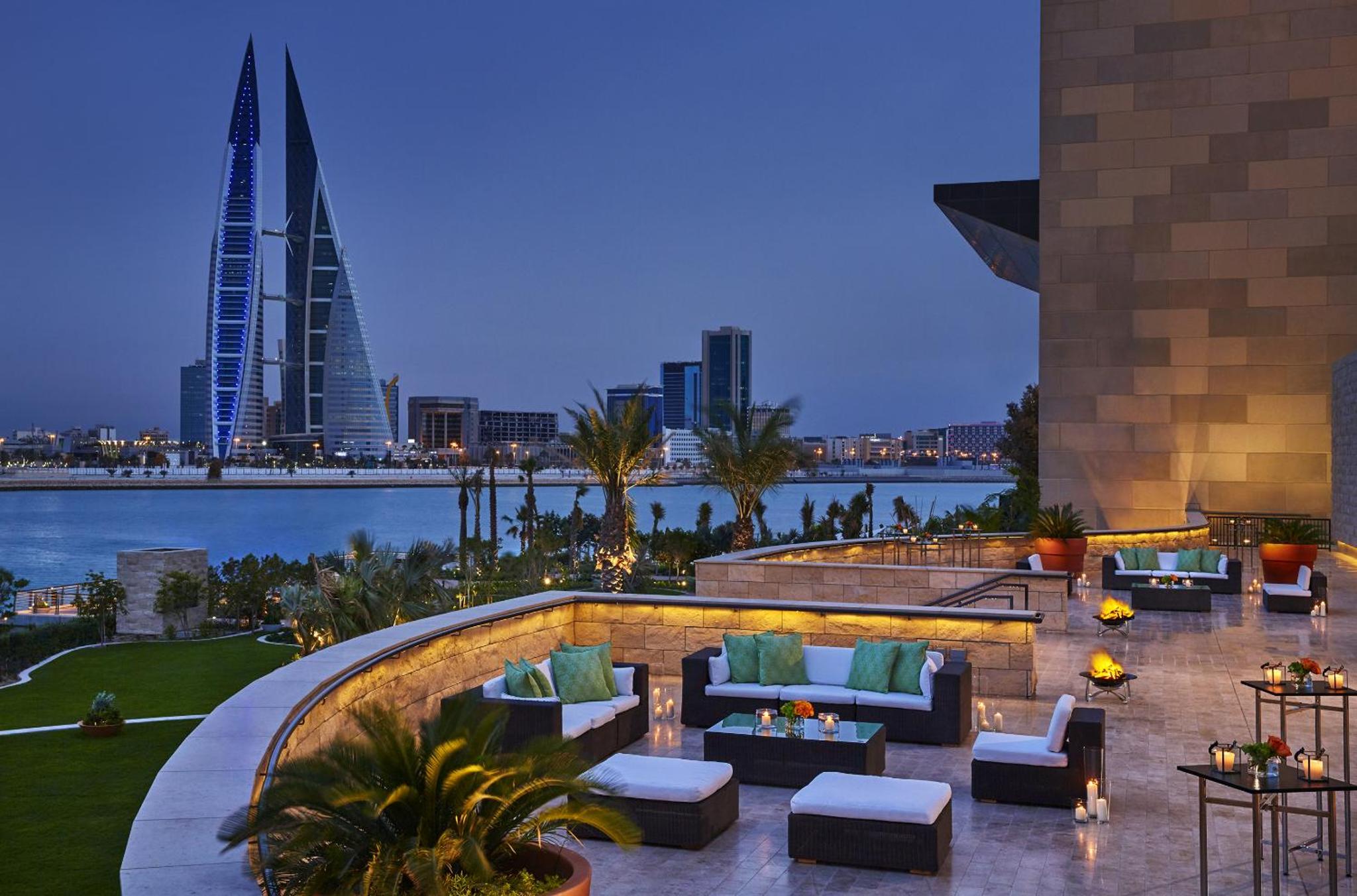 a hotel patio with couches and a view of a city at Four Seasons Hotel Bahrain Bay in Manama