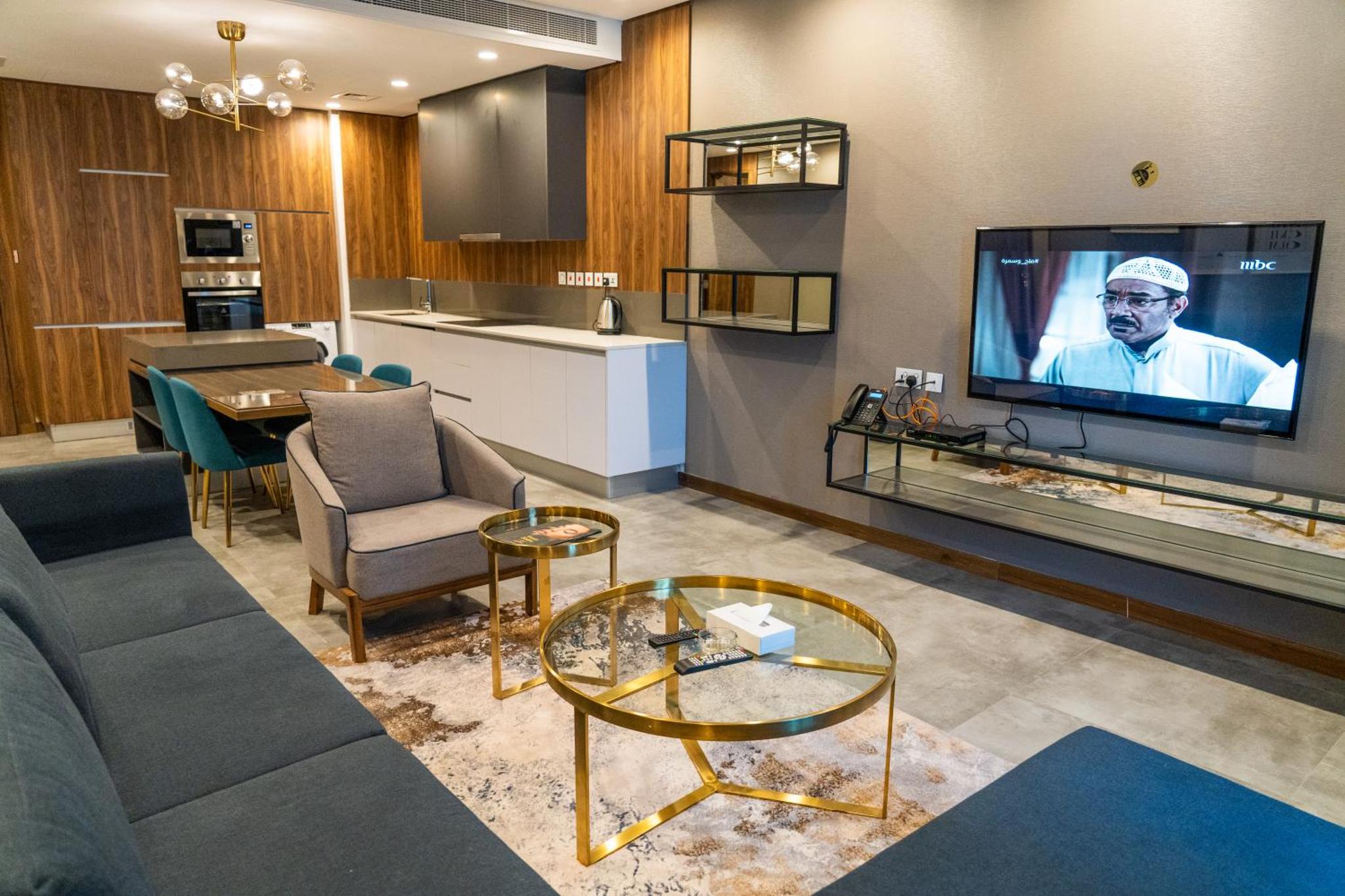 a living room with a couch and a tv at Modern Heights in Juffair