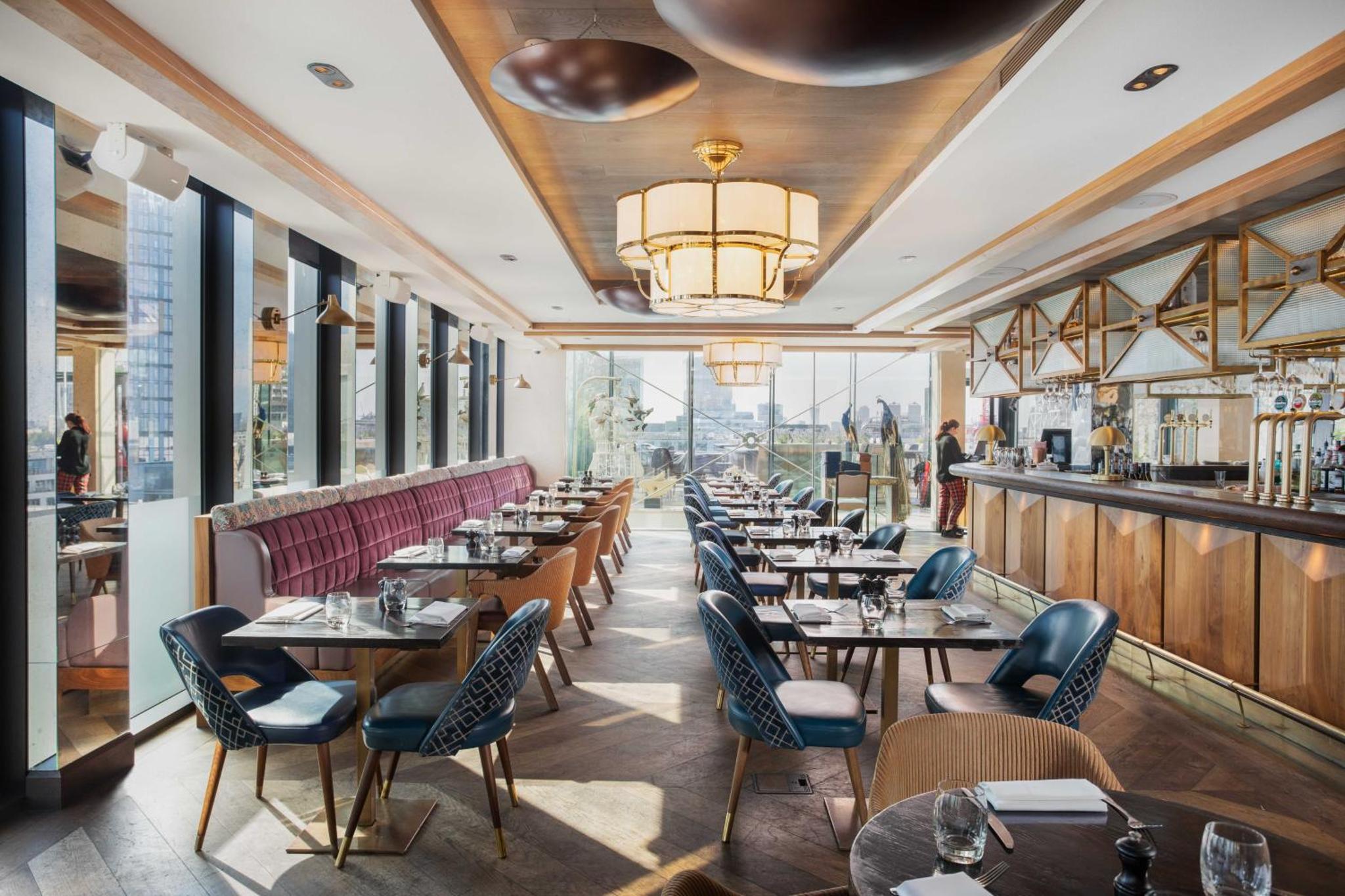 a restaurant with tables and chairs and a bar at Montcalm Royal London House, London City in London