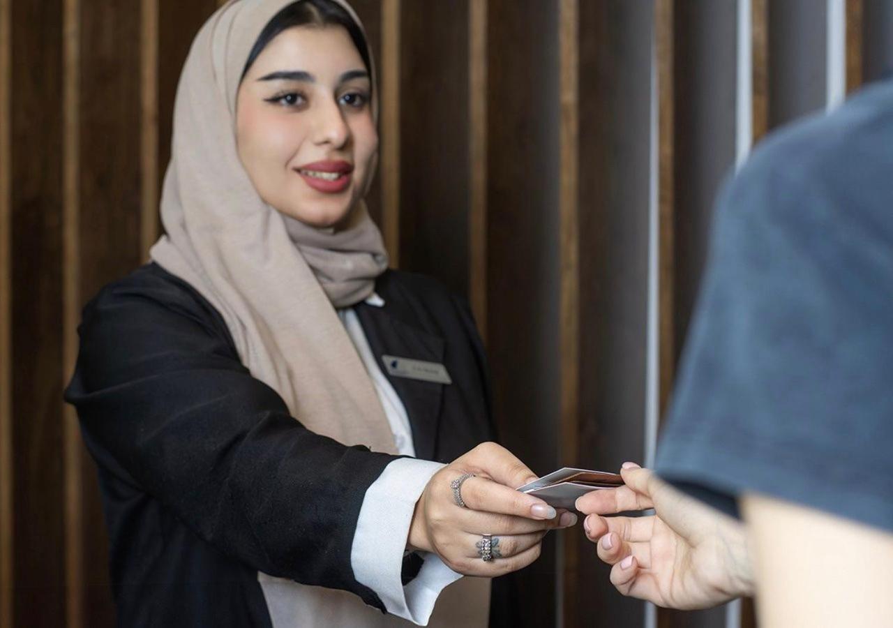 a woman in a hijab holding a cell phone at SeaLoft Villas in Manama +58 photos