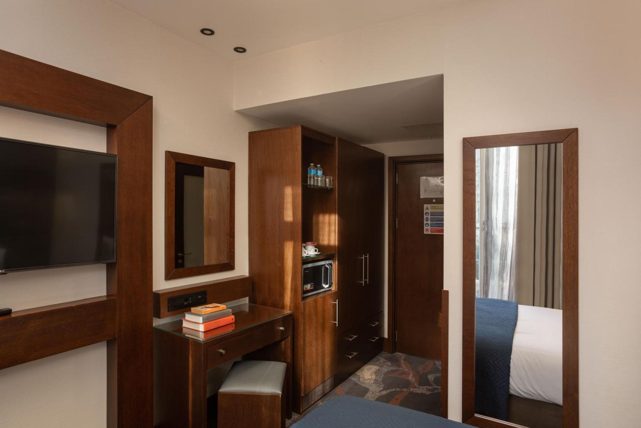 a hotel room with a bed and a television at Montcalm Chilworth Townhouse, Paddington in London