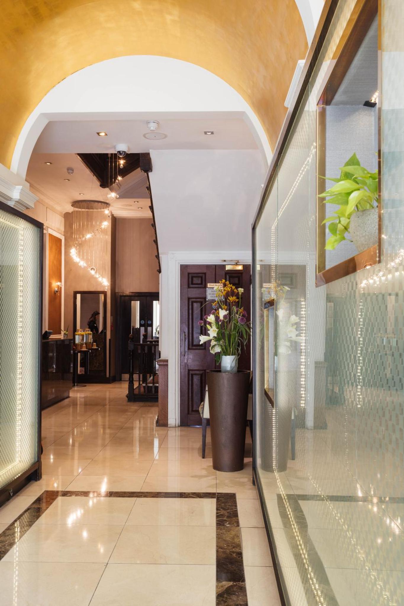 a lobby with an archway and a plant in a pot at Park Grand Mayfair in London