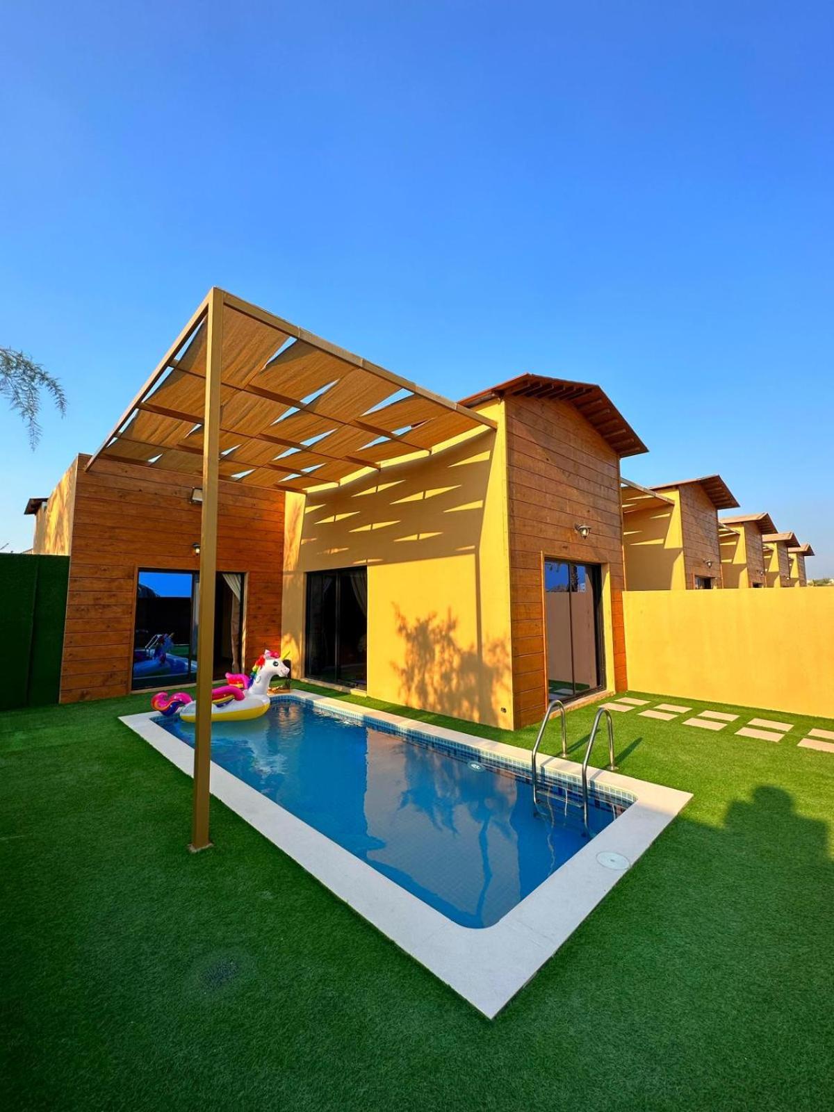 a house with a swimming pool in the yard at Cielo Beach Resort in Al Qaryah