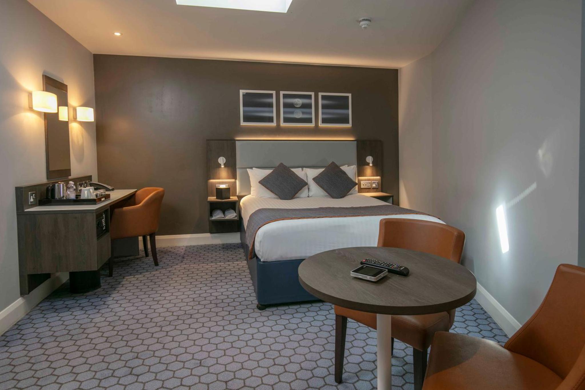 a hotel room with a bed and a desk at Best Western Plus Vauxhall Hotel in London
