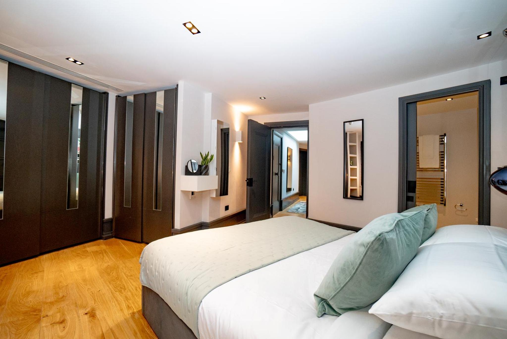a bedroom with a large white bed and some windows at Stay Kula London - Covent Garden Garrick St in London