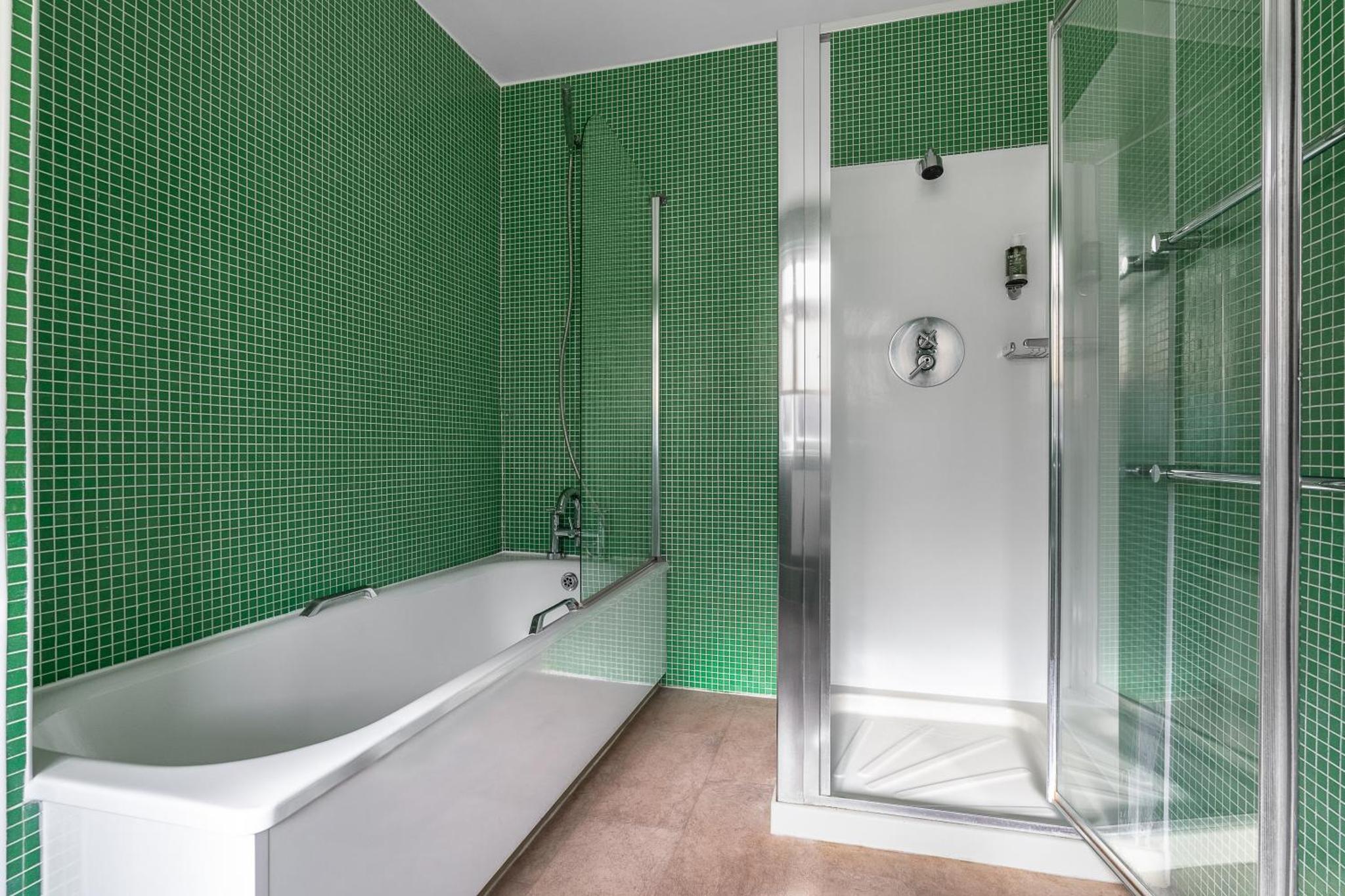 a green tiled bathroom with a tub and a shower at Harlingford Hotel in London