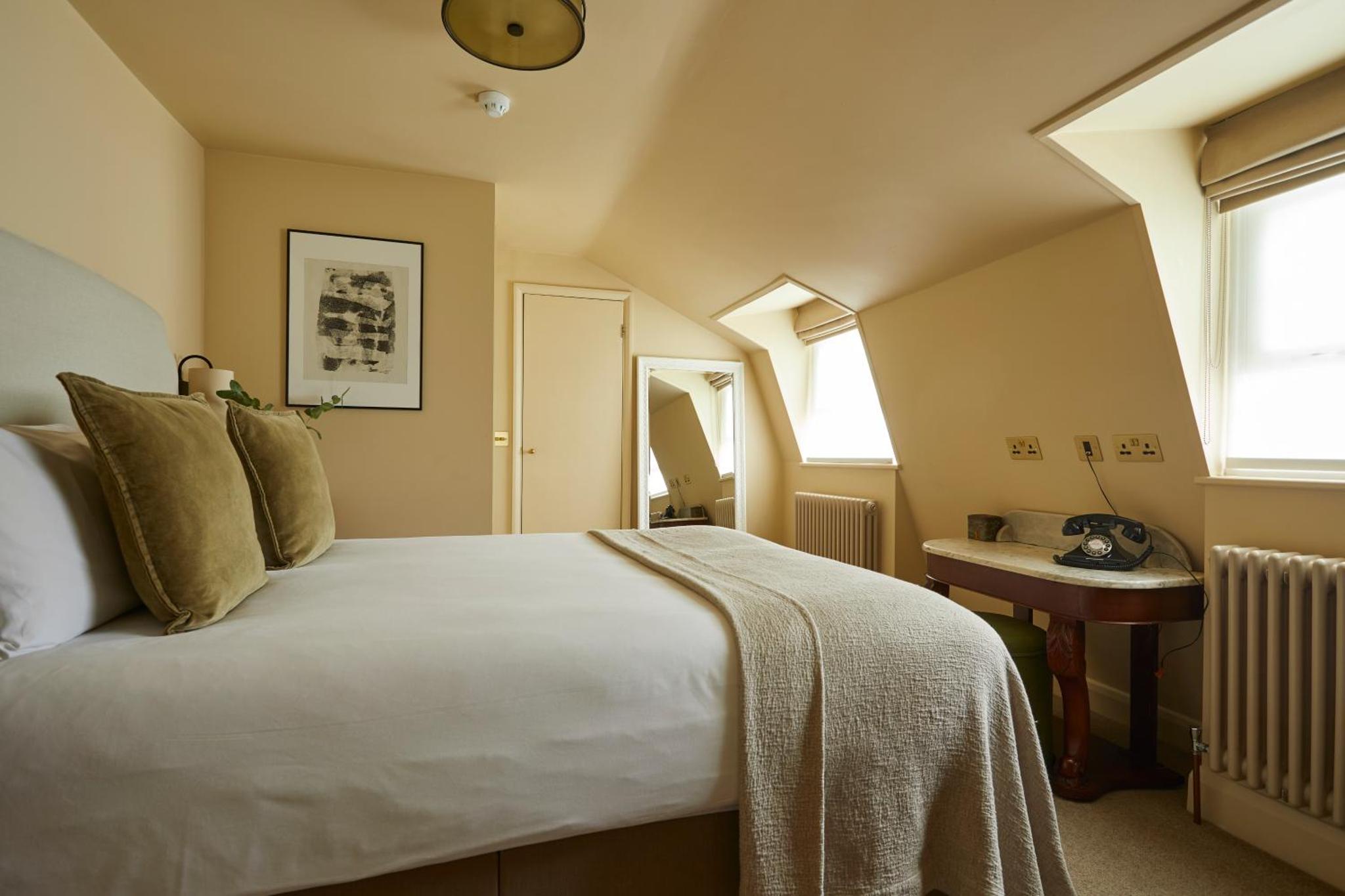 a bedroom with a large bed and a table at Georgian House Hotel in London