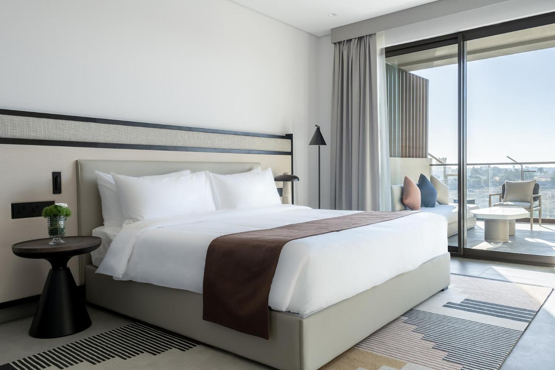 a bedroom with a large white bed and a balcony at Fraser Suites Al Liwan in Manama +11 photos