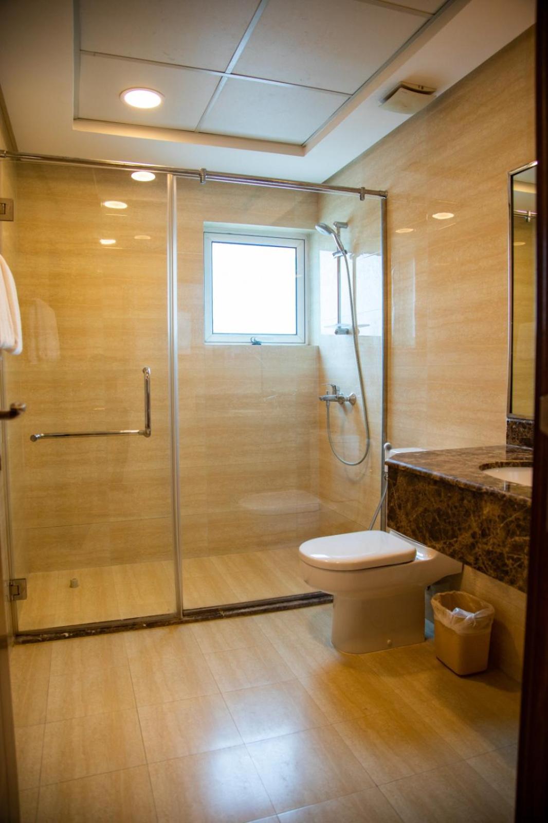 a bathroom with a shower and a toilet and a sink at Ginger Luxury House in Juffair