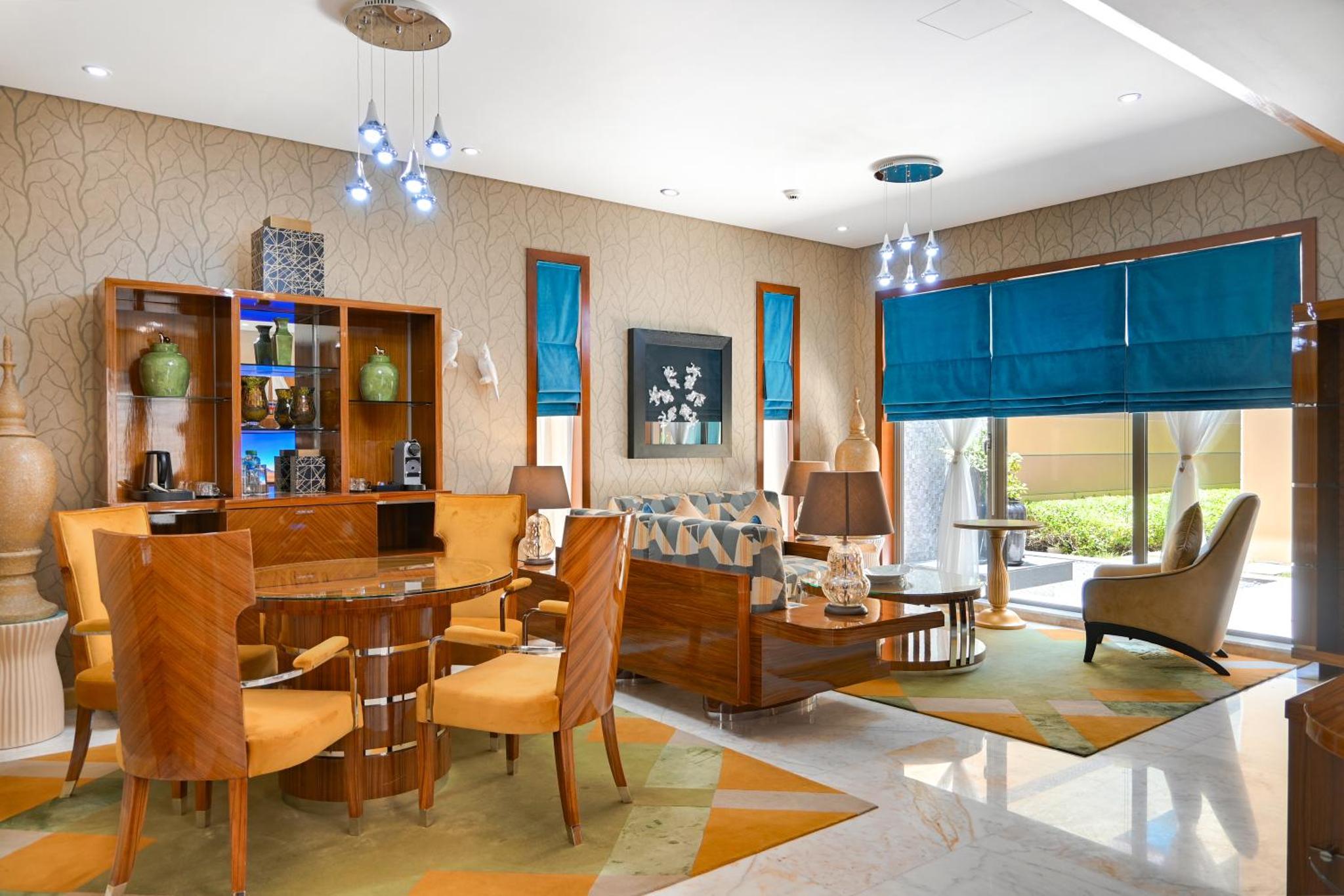 a living room with a dining room table and chairs at Palavra Resort in Manama +112 photos