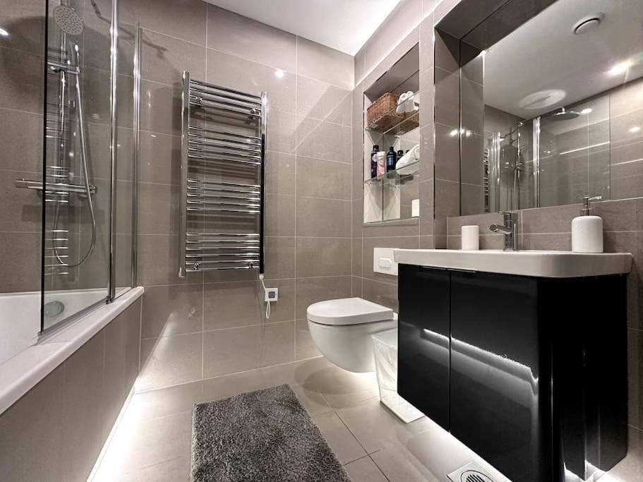 a bathroom with a toilet and a sink and a shower at The Glamour of Shoreditch in London