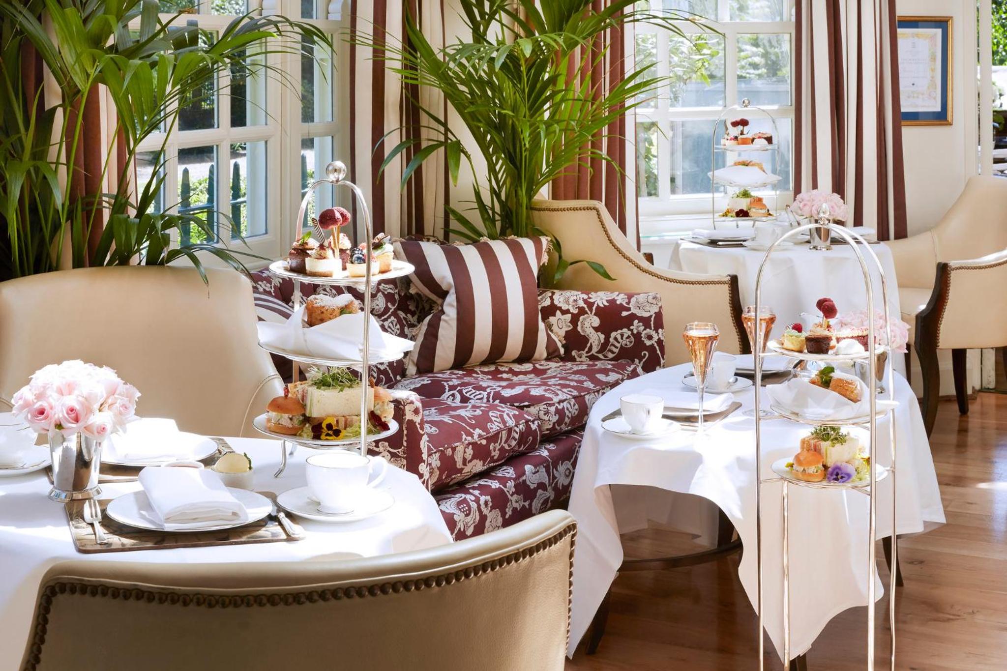 a dining room with two tables and a couch at The Montague On The Gardens in London