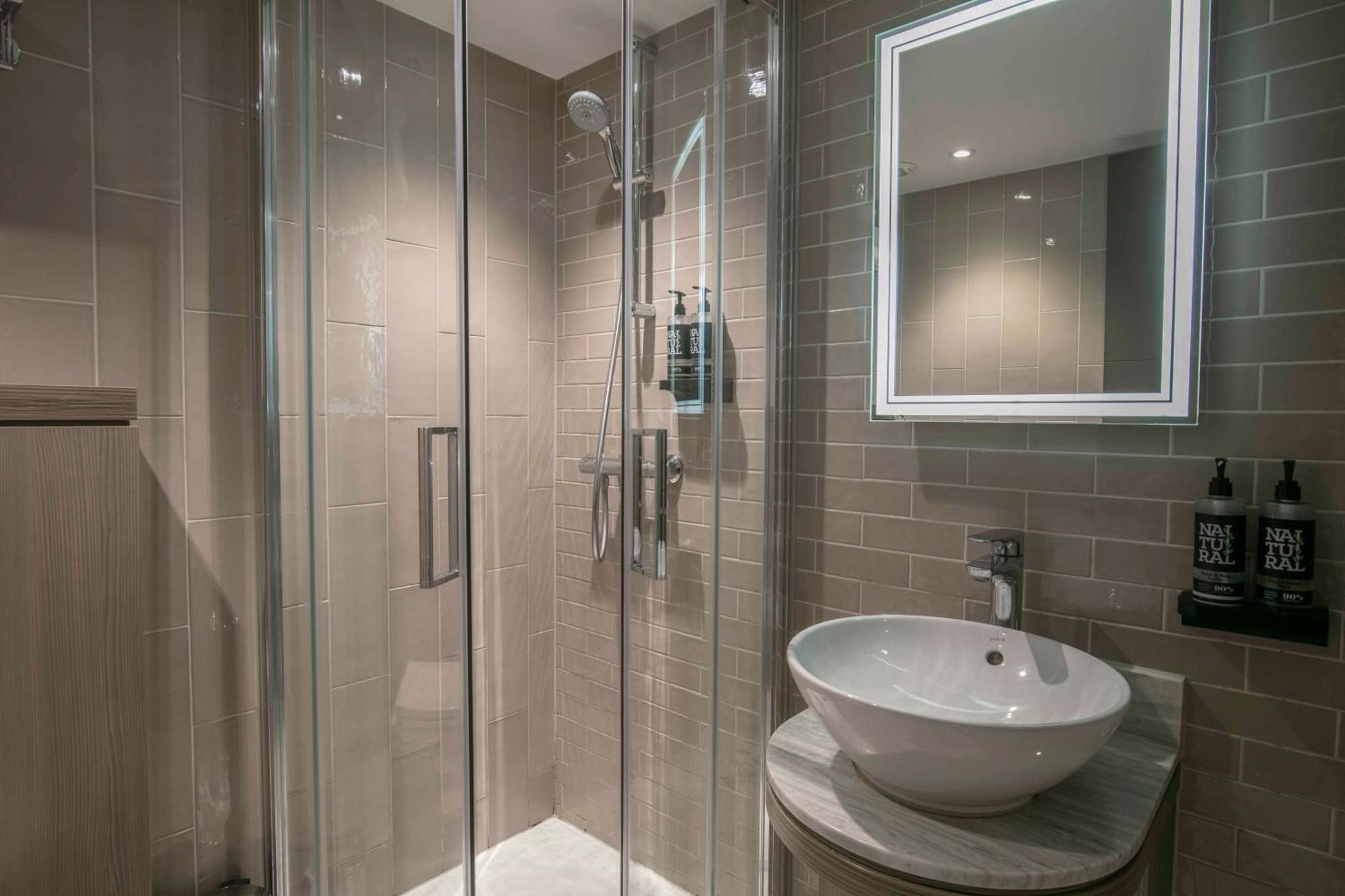 a bathroom with a glass shower with a sink at Best Western Plus Vauxhall Hotel in London +67 photos