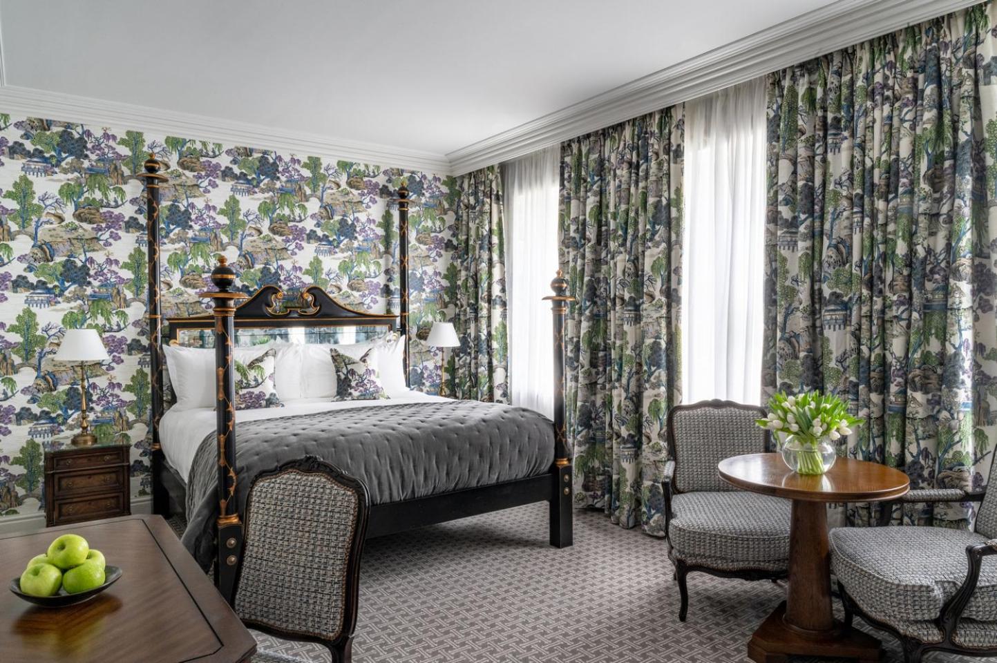 a bedroom with a bed and a table and chairs at The Kensington Hotel in London
