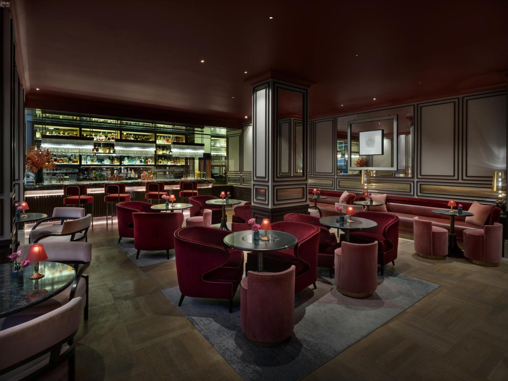 a restaurant with tables and chairs and a bar at The Biltmore Mayfair in London