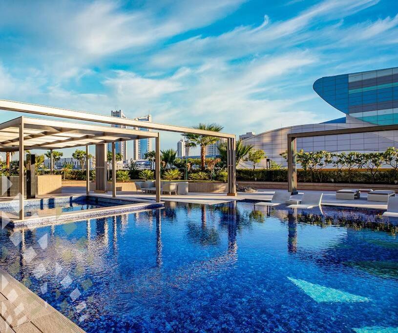 a large swimming pool in front of a building at Cozy Stay in Manama