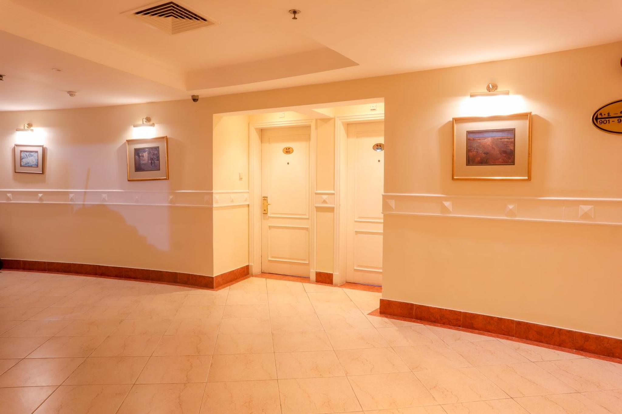 a room with a hallway with paintings on the walls at Palette Luxury Marina View Formerly Happy Days Hotel in Manama