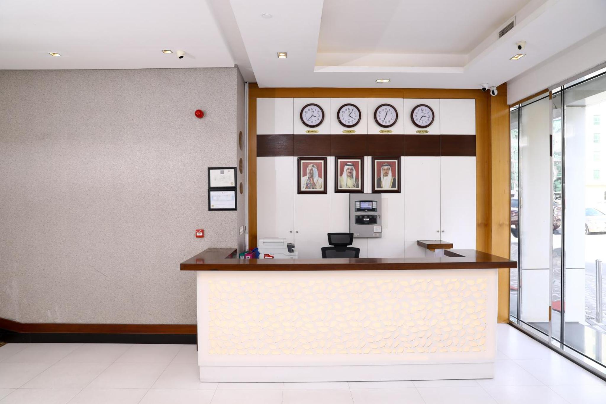 a lobby with a counter and clocks on the wall at Landway Suite in Manama +94 photos