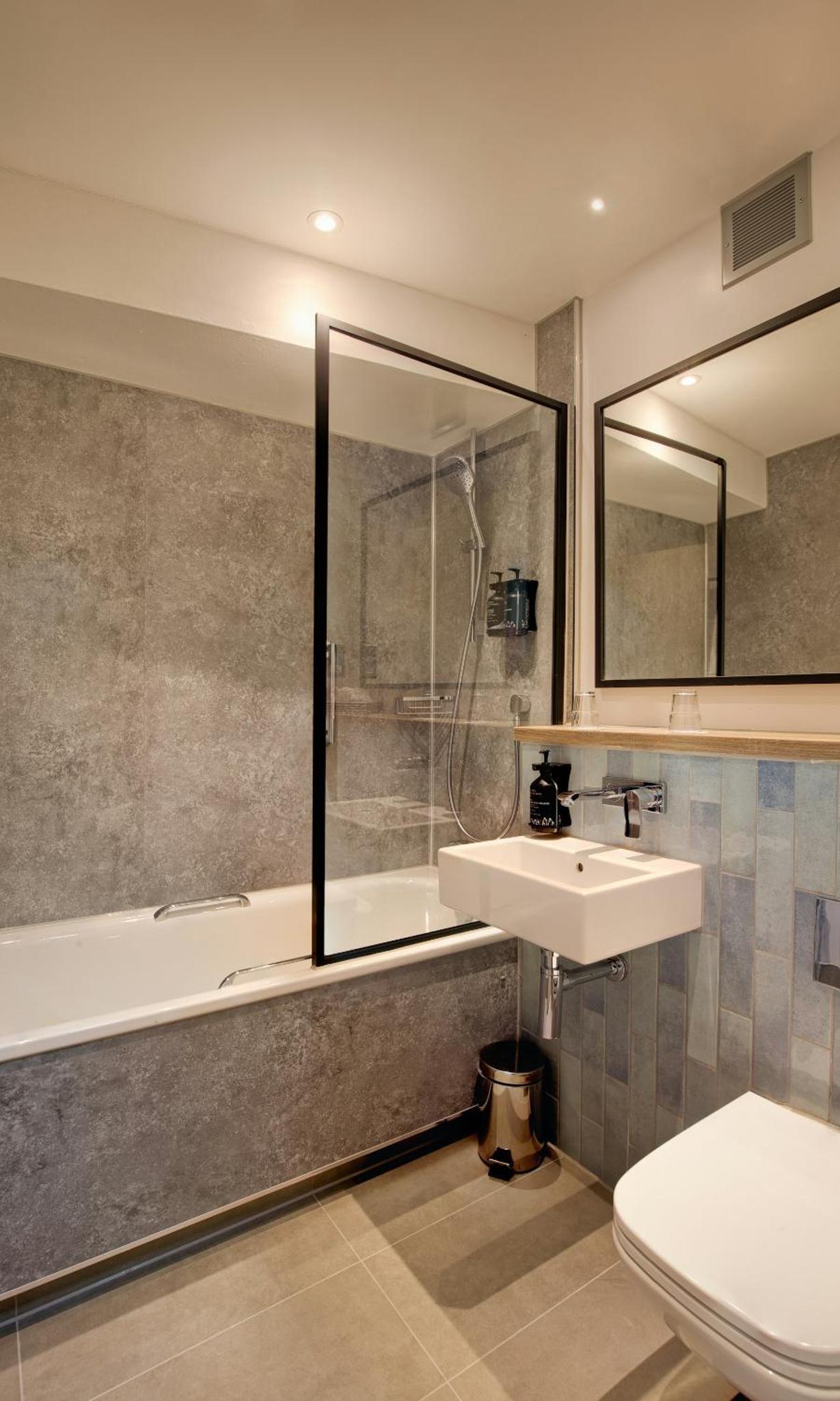 a bathroom with a sink and a bath tub at President Hotel in London