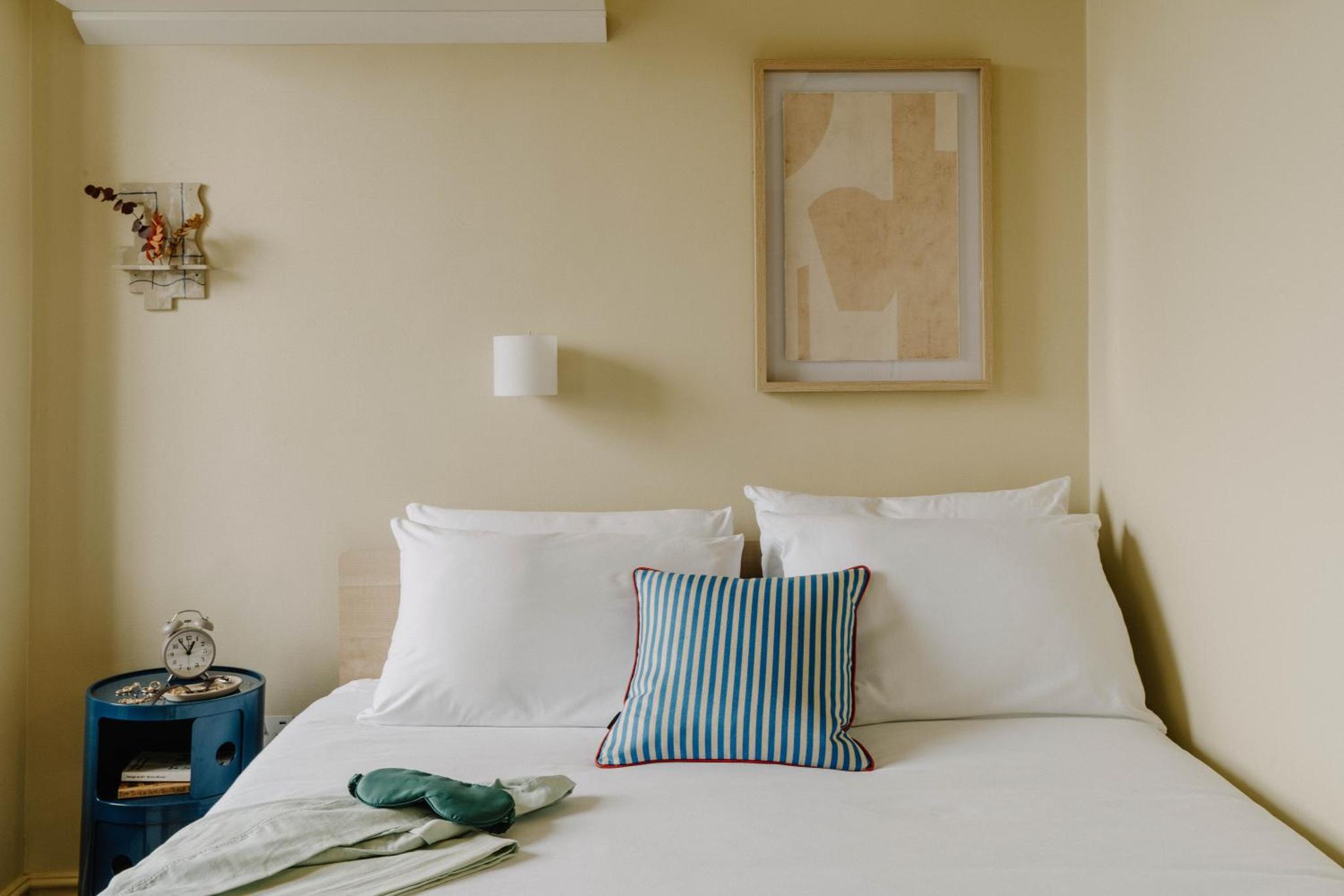 a bed with white pillows and a picture on the wall at Mason & Fifth, Primrose Hill in London +82 photos