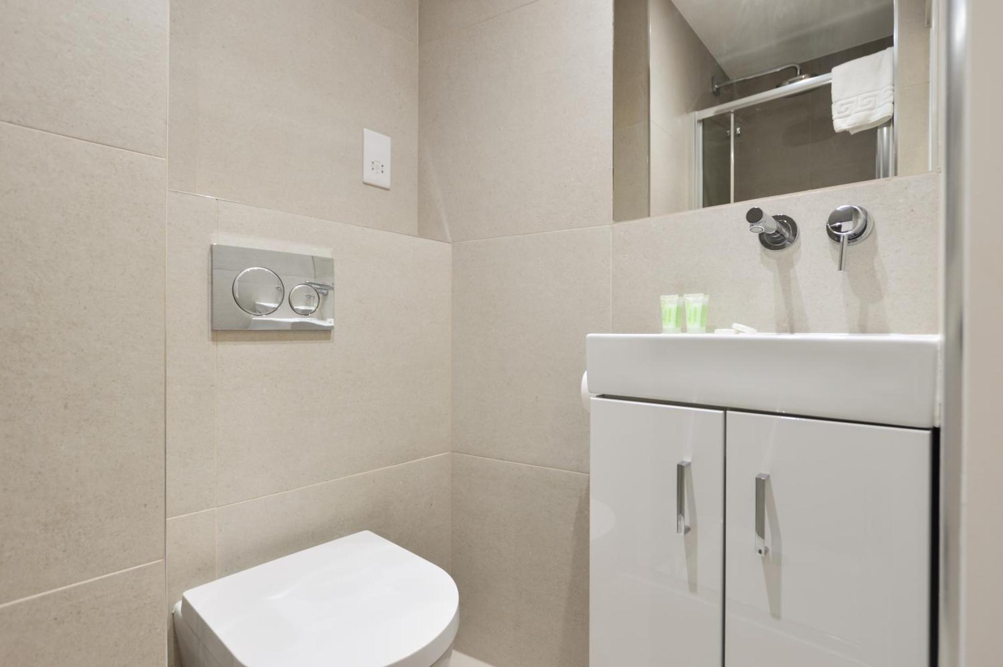 a bathroom with a white toilet and a sink at StayPrime Fitzrovia Serviced Apartments in London