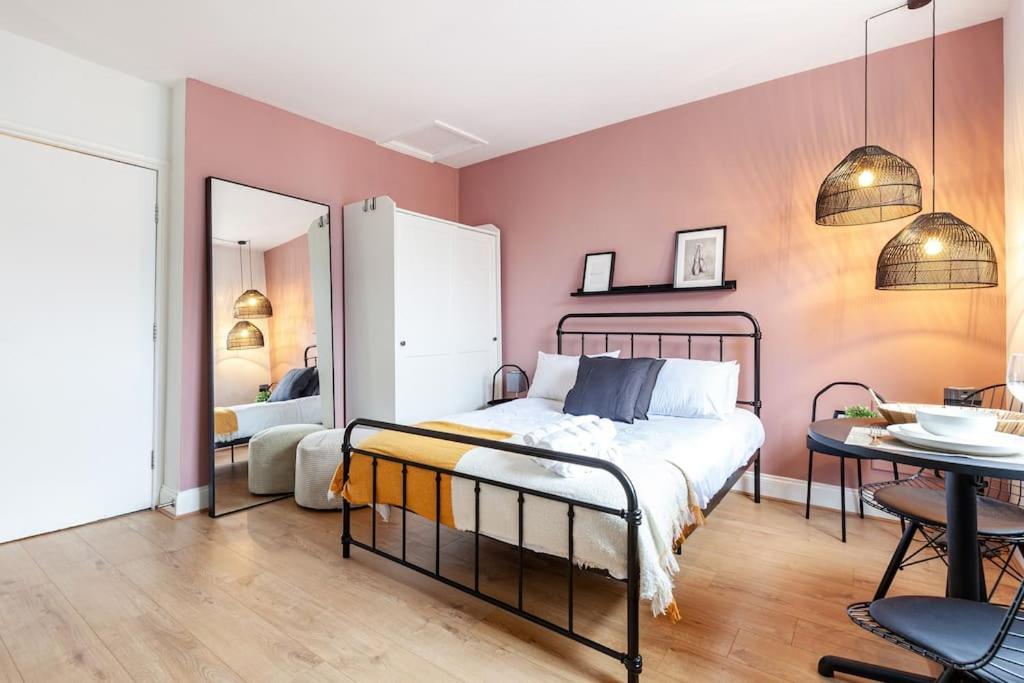 a bedroom with a bed and a table and a mirror at Beautiful Studio in Bayswater in London