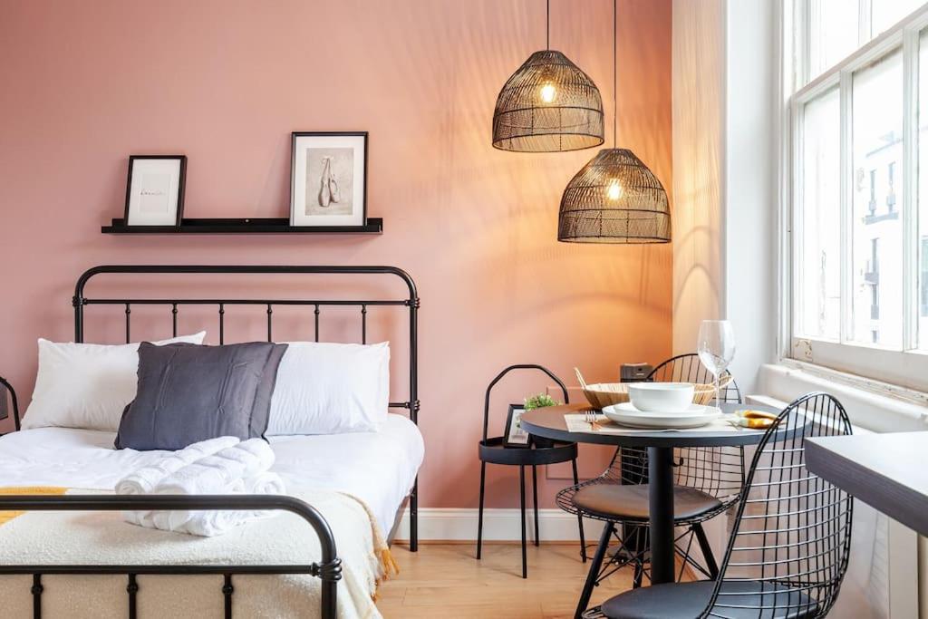 a bedroom with a bed and a table and chairs at Beautiful Studio in Bayswater in London