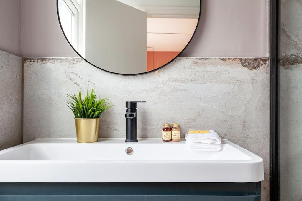 a bathroom with a white sink and a mirror at Beautiful Studio in Bayswater in London