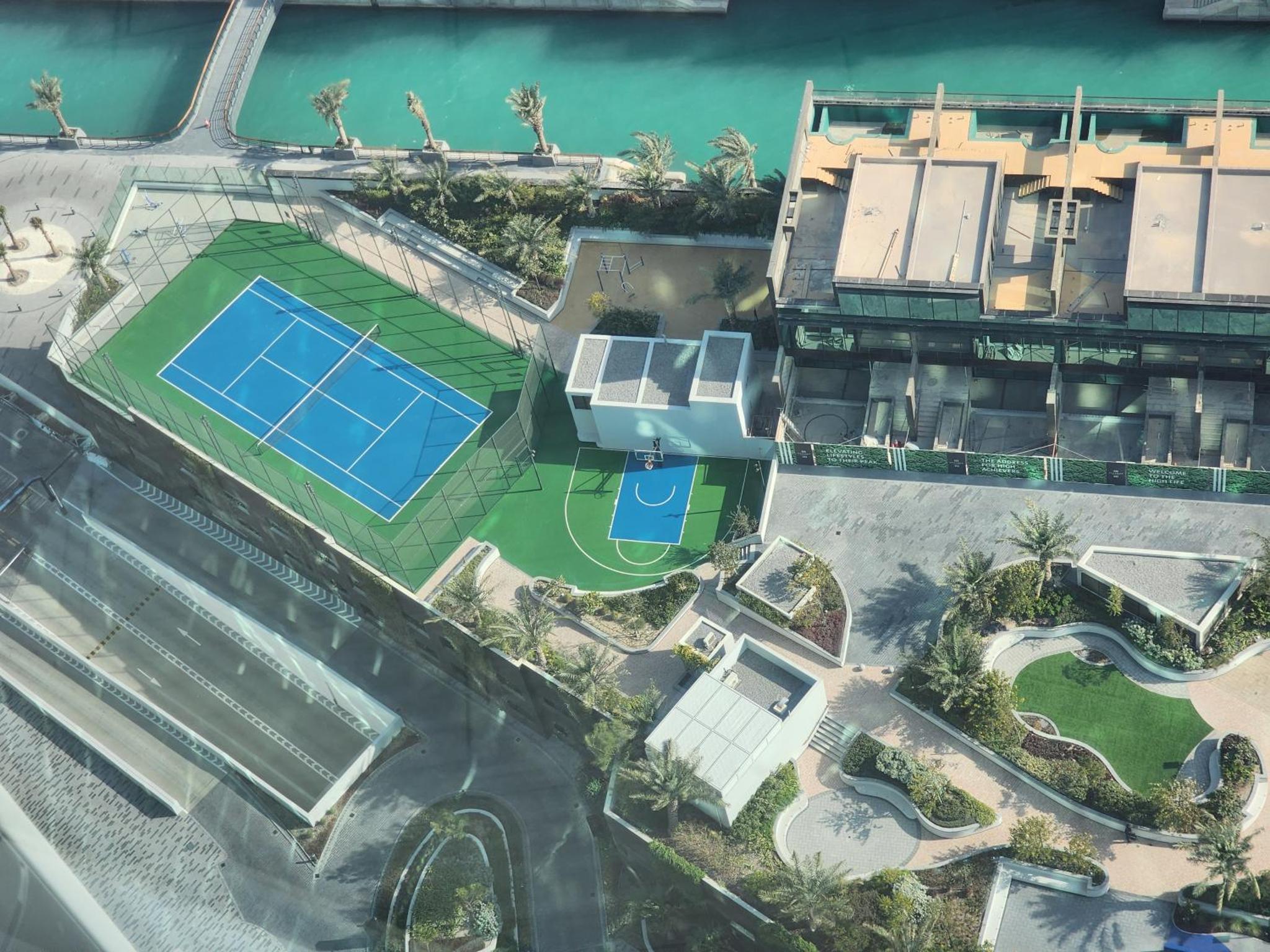 an aerial view of a building with a pool and a house at Premium Garden View Studio Harbour Heights in Manama