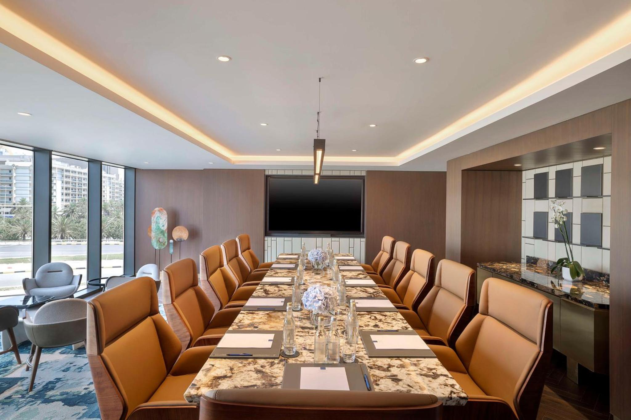a conference room with a long table and chairs at Conrad Bahrain Financial Harbour in Manama +83 photos