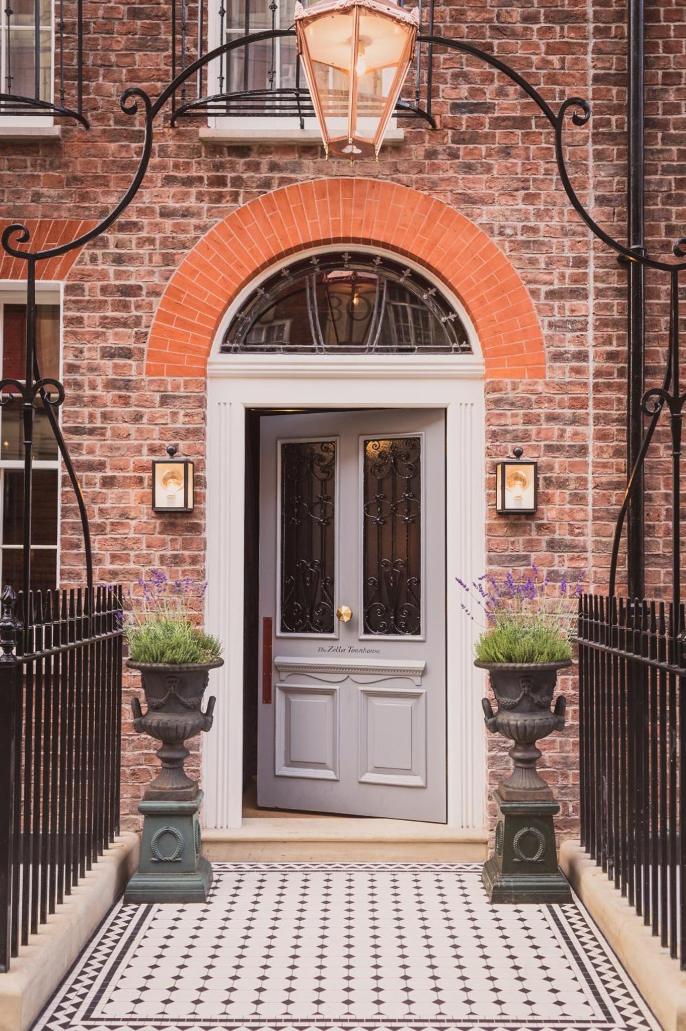 a gray door on a brick building with plants at The Zetter Marylebone in London