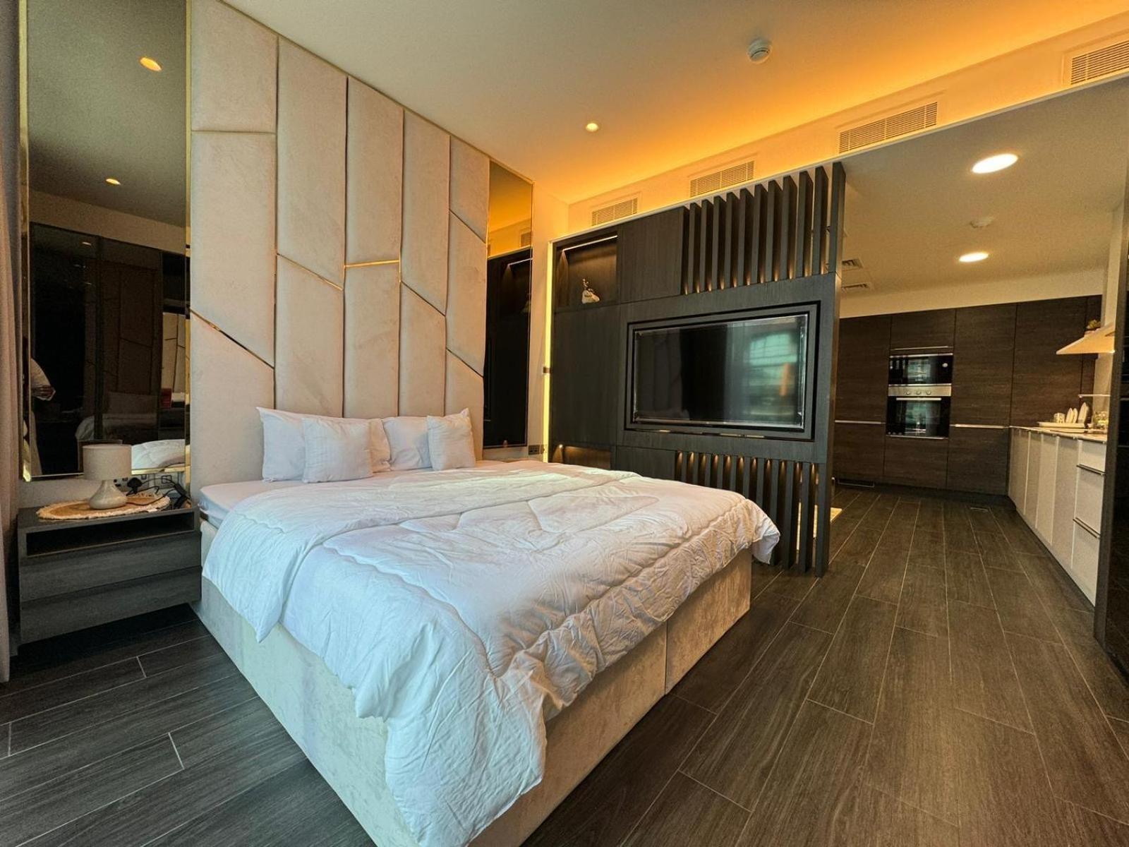 a bedroom with a large bed and a flat screen tv at Harbor Row in Manama +11 photos