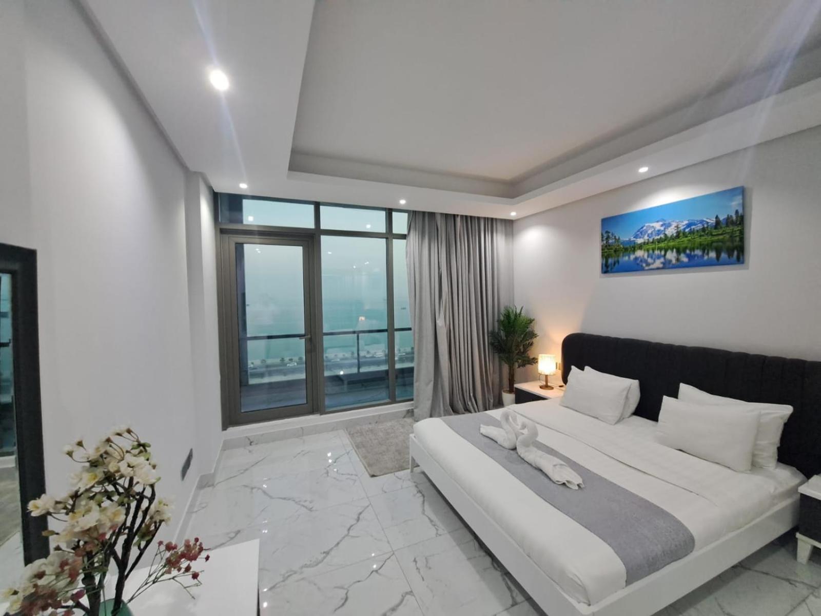 a bedroom with a large bed and a large window at Al Safwa One in Al Ḩadd +119 photos