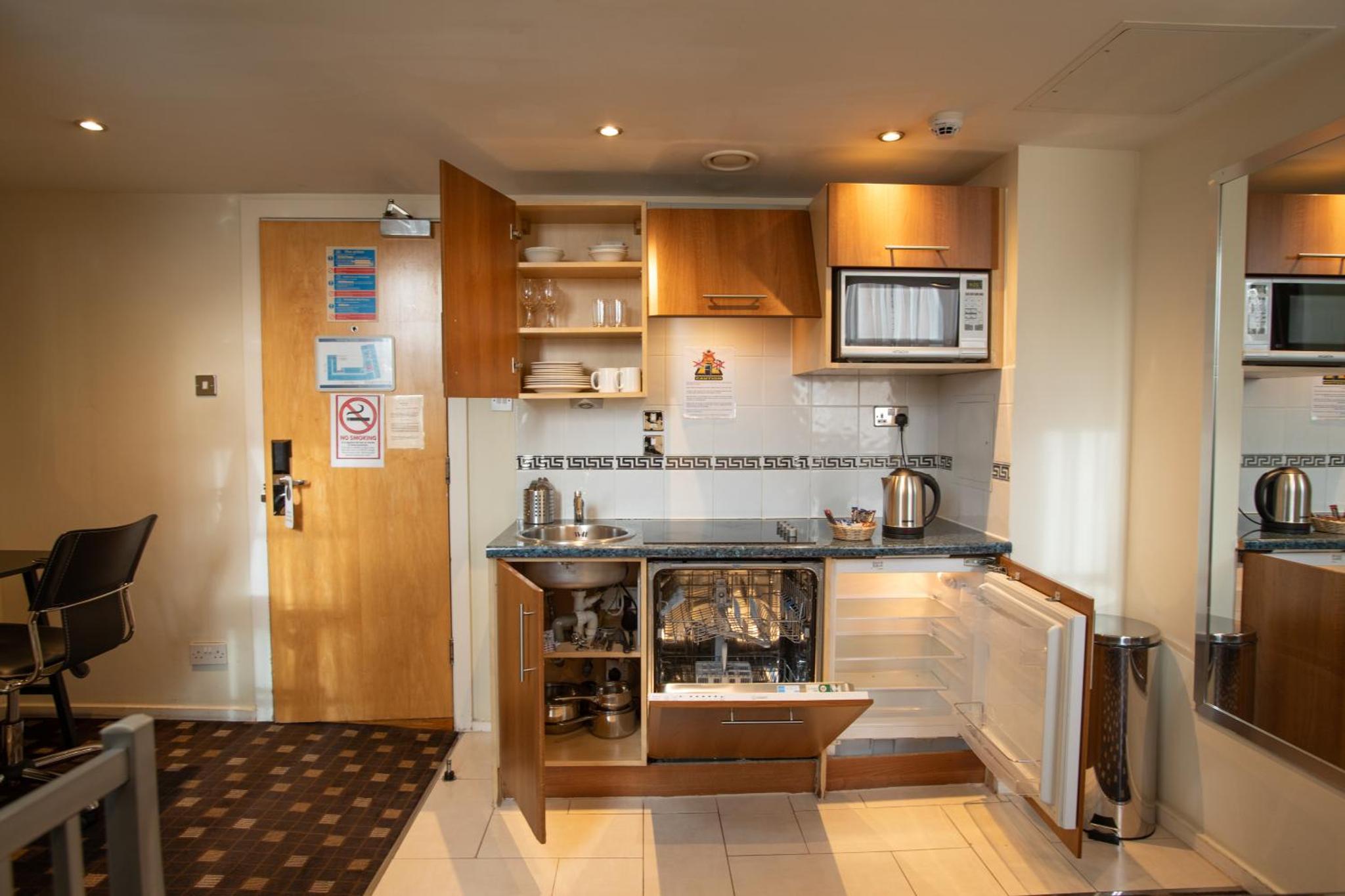 a kitchen with wooden cabinets and a counter top at Grand Plaza Serviced Apartments in London