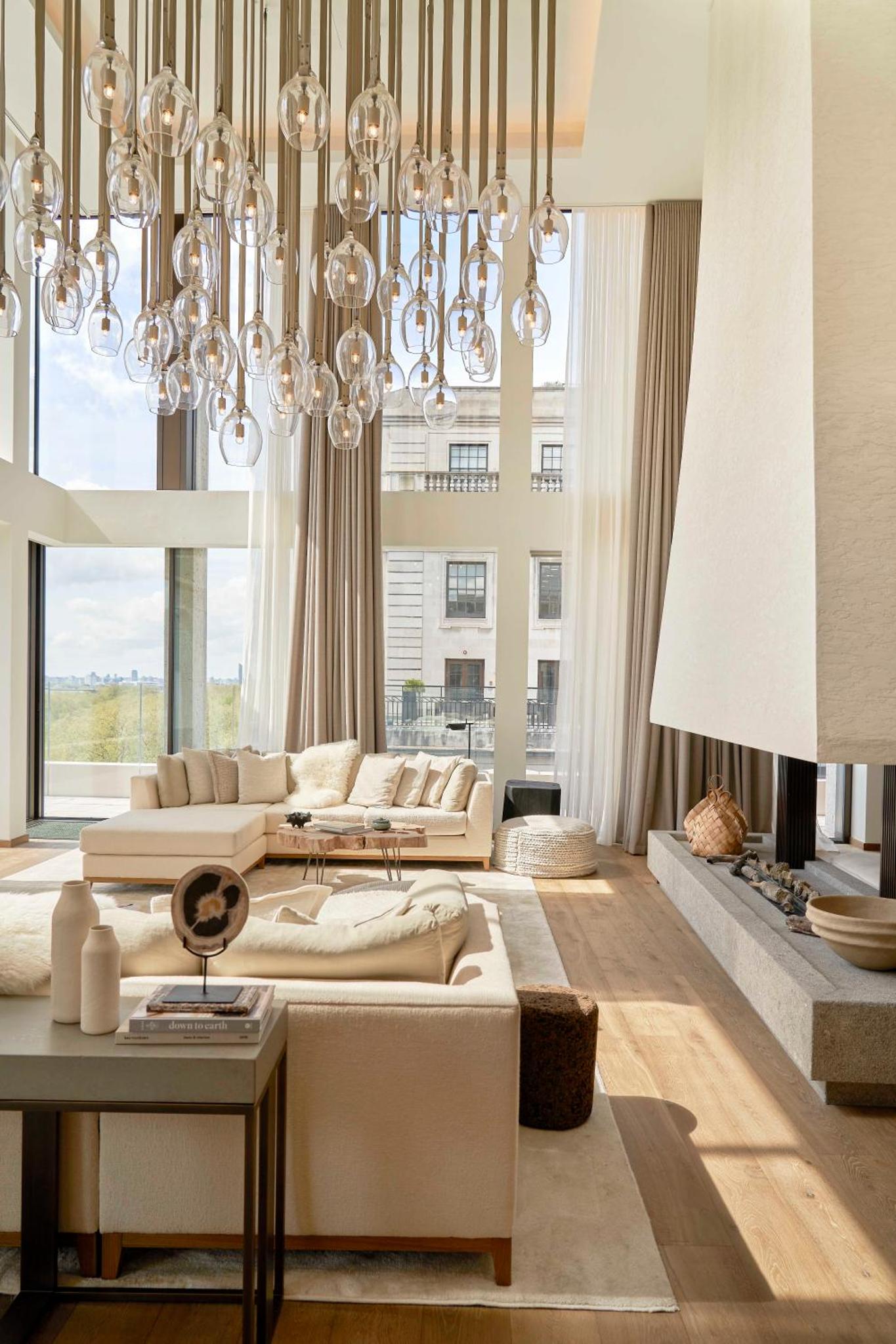 a living room with a couch and a chandelier at 1 Hotel Mayfair in London