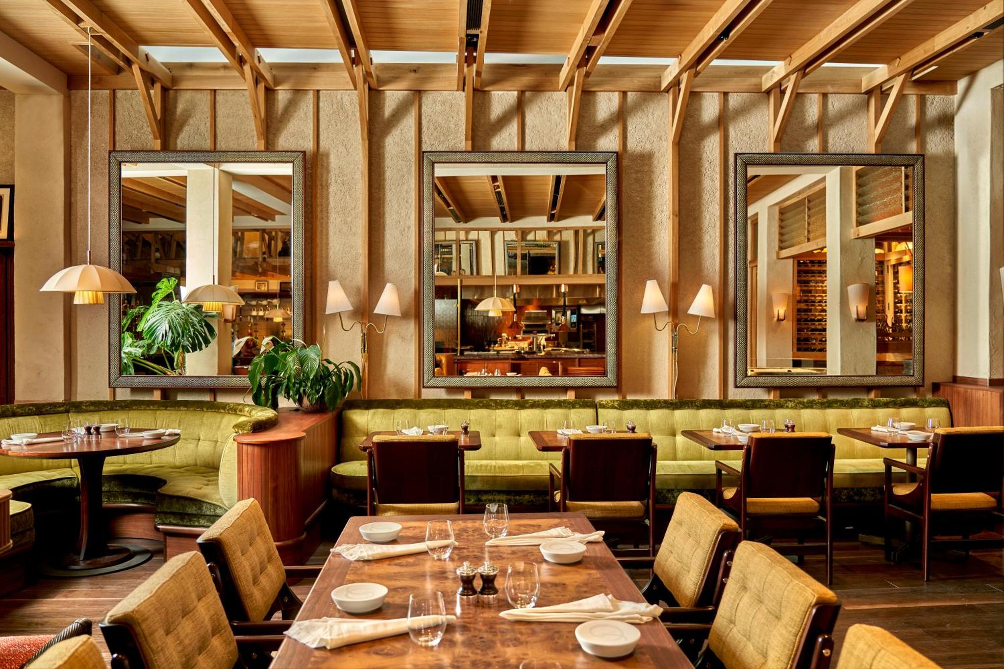 a restaurant with tables and chairs and mirrors at 1 Hotel Mayfair in London