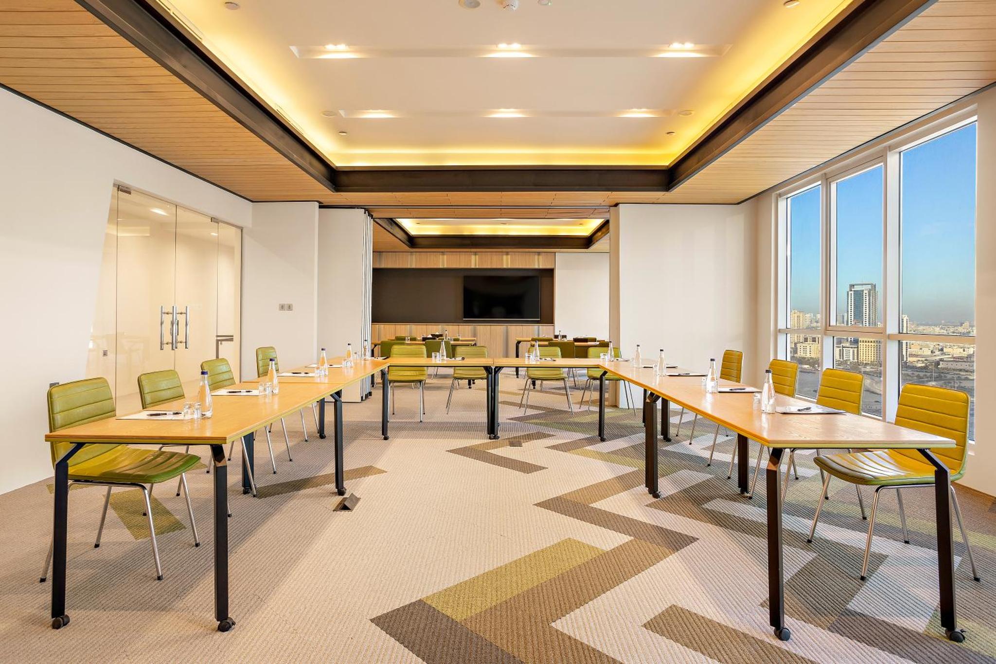 a conference room with tables and chairs and windows at Barcelo Hotel & Residences, Bahrain in Manama +39 photos