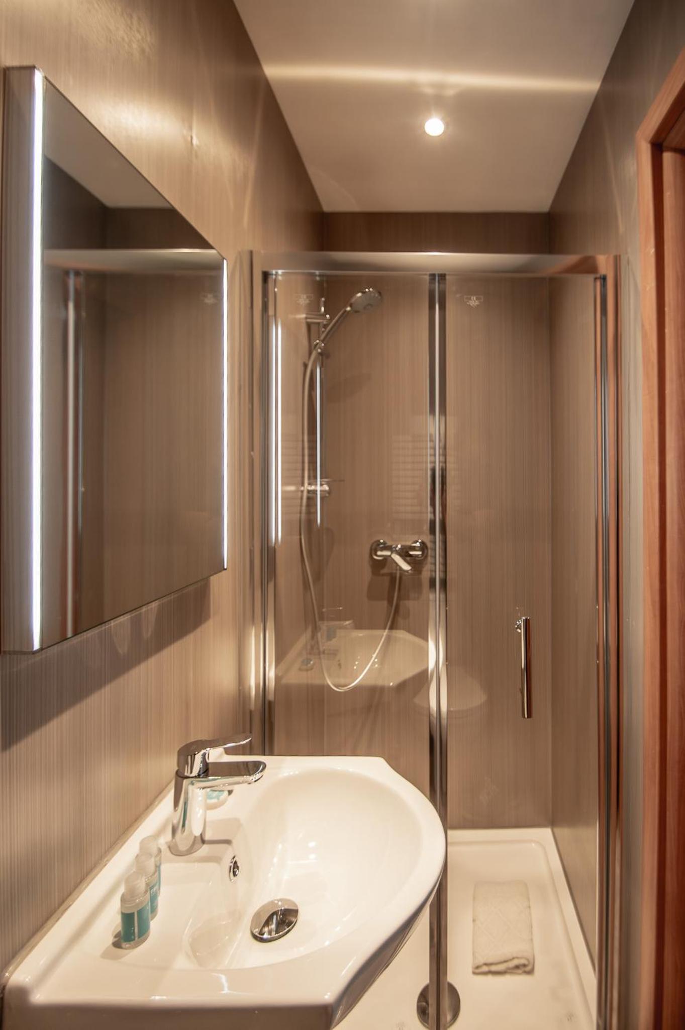 a bathroom with a sink and a shower at New Kent Apartments in London