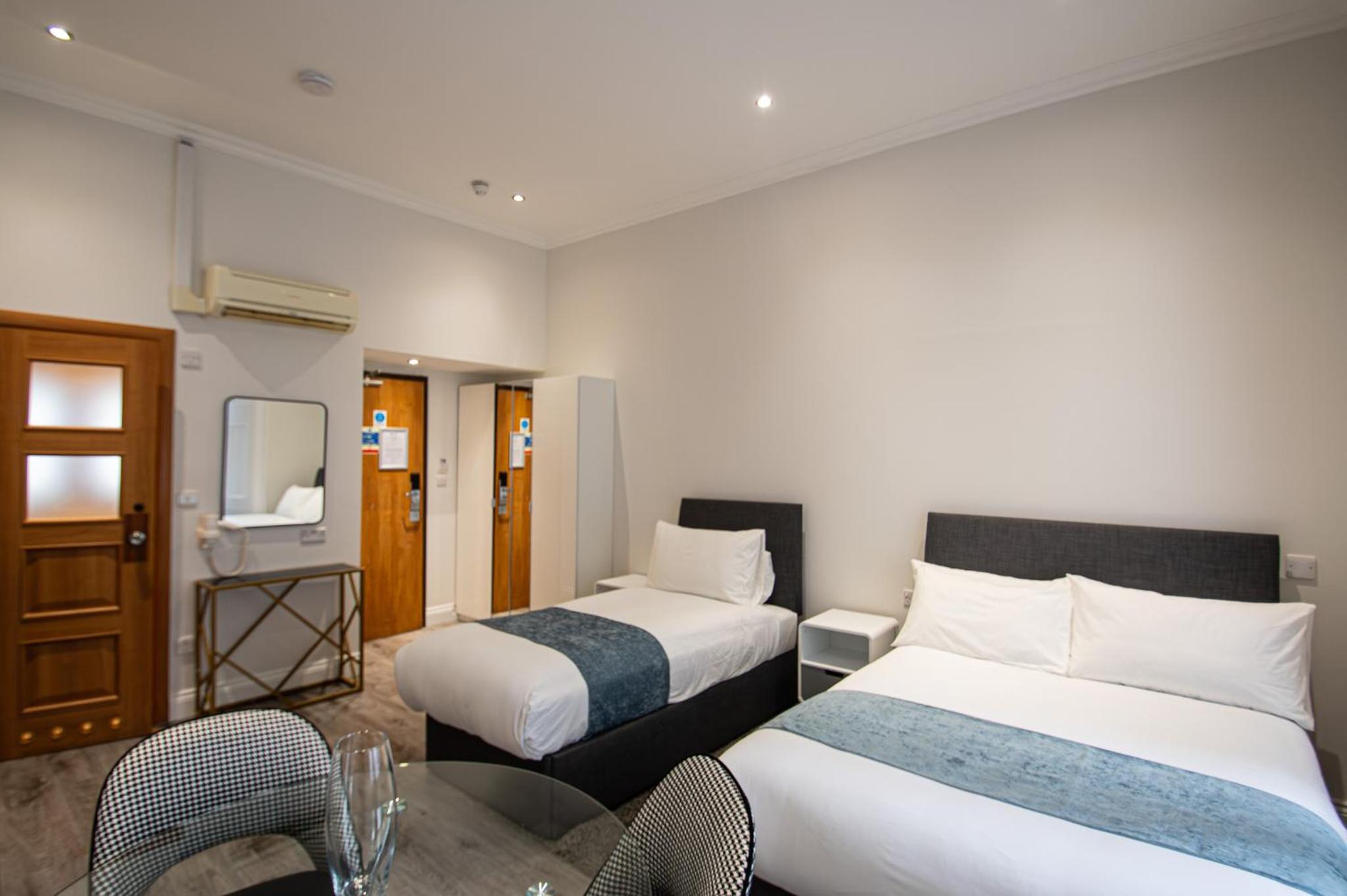 a hotel room with two beds and a television at New Kent Apartments in London