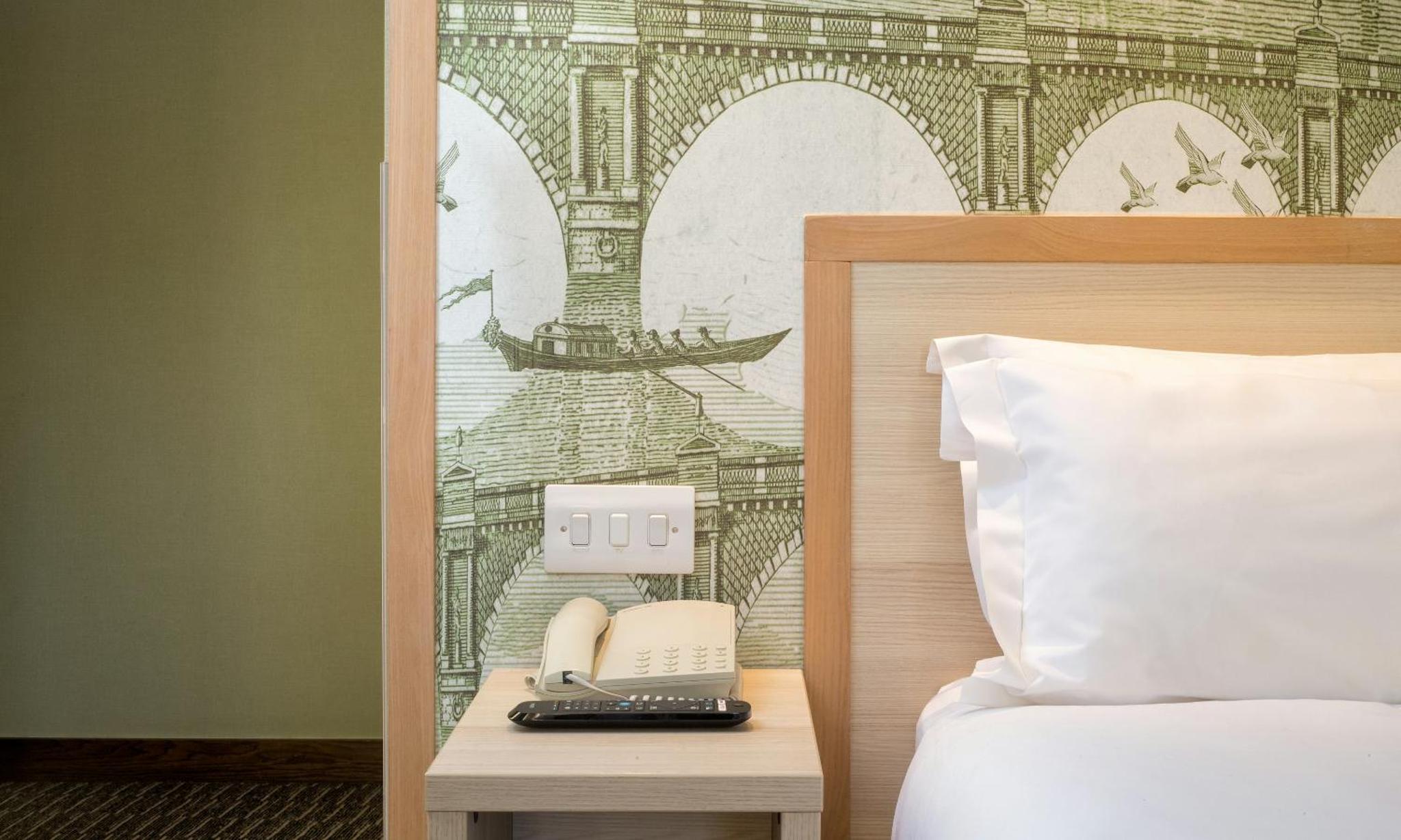 a hotel room with a bed and a phone on a table at President Hotel in London +87 photos