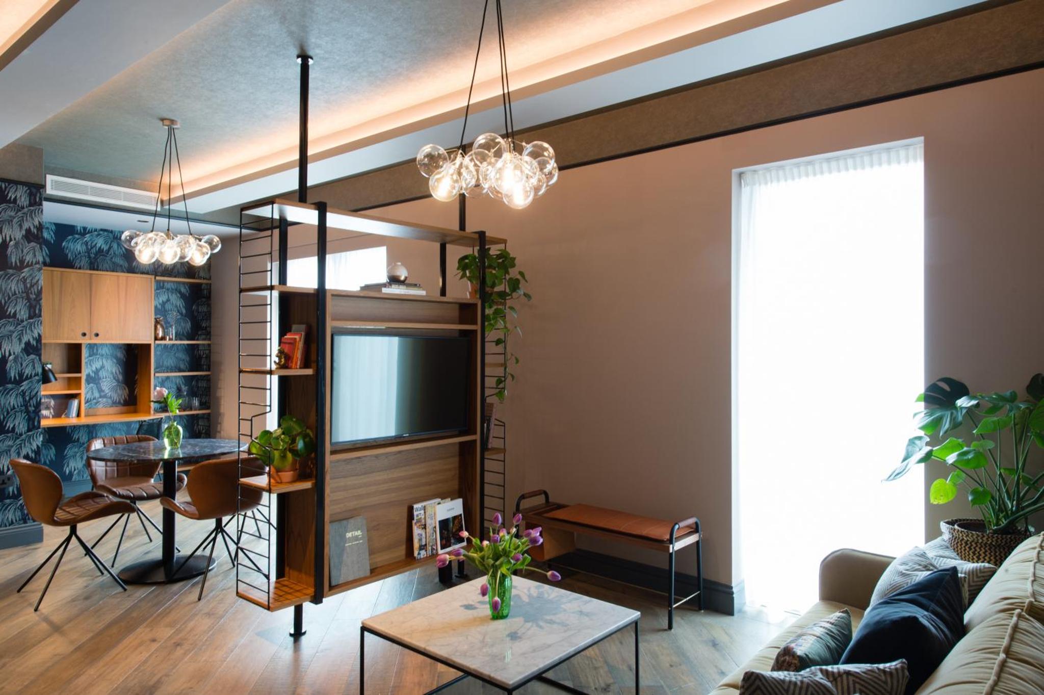 a living room with a couch and a table at Clayton Hotel City of London, Tower Bridge in London +40 photos