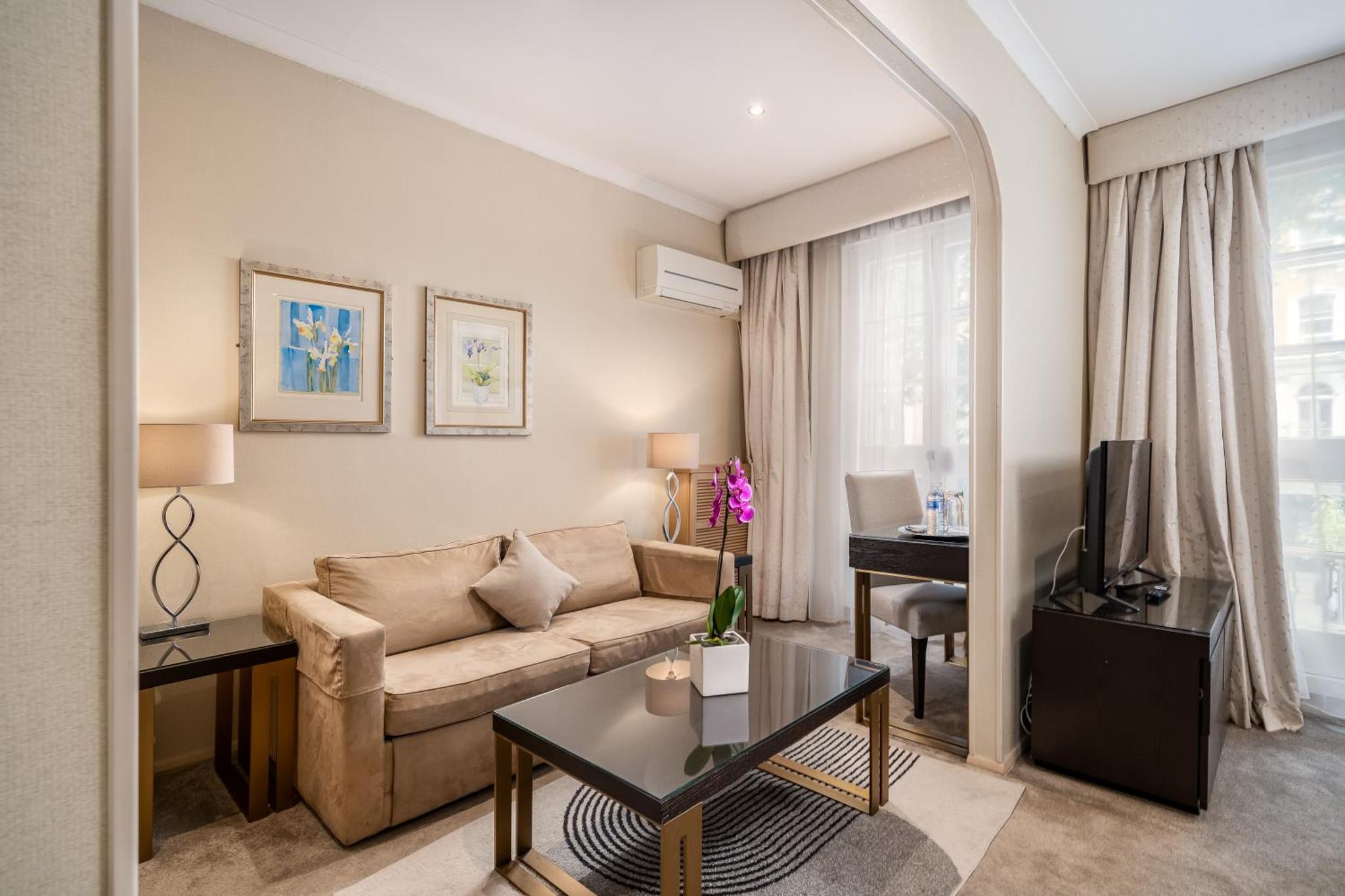 a living room with a couch and a table at The Beaufort Hotel in London