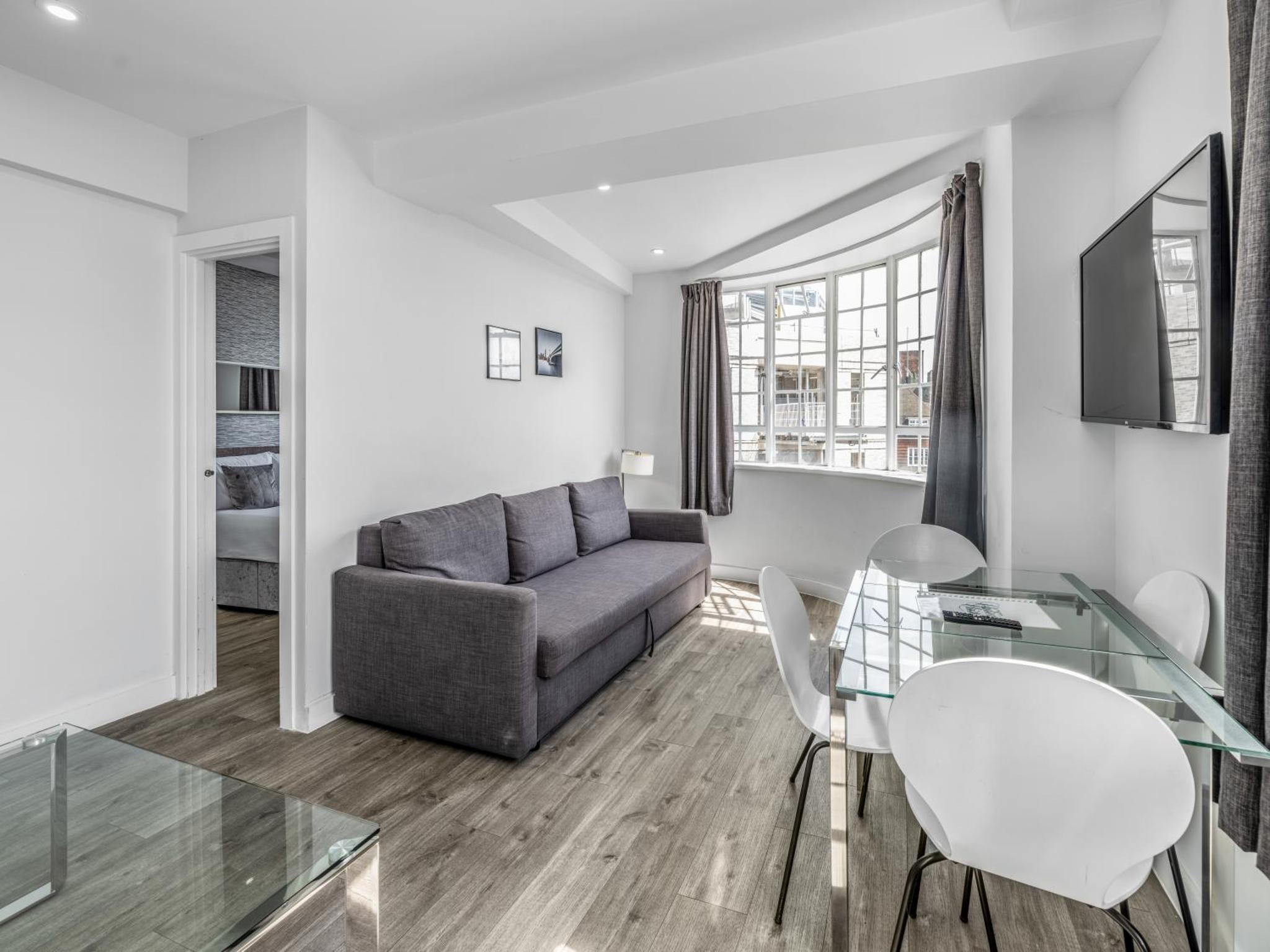 a living room with a couch and a glass table at Chelsea Cloisters Serviced Apartments in London +74 photos