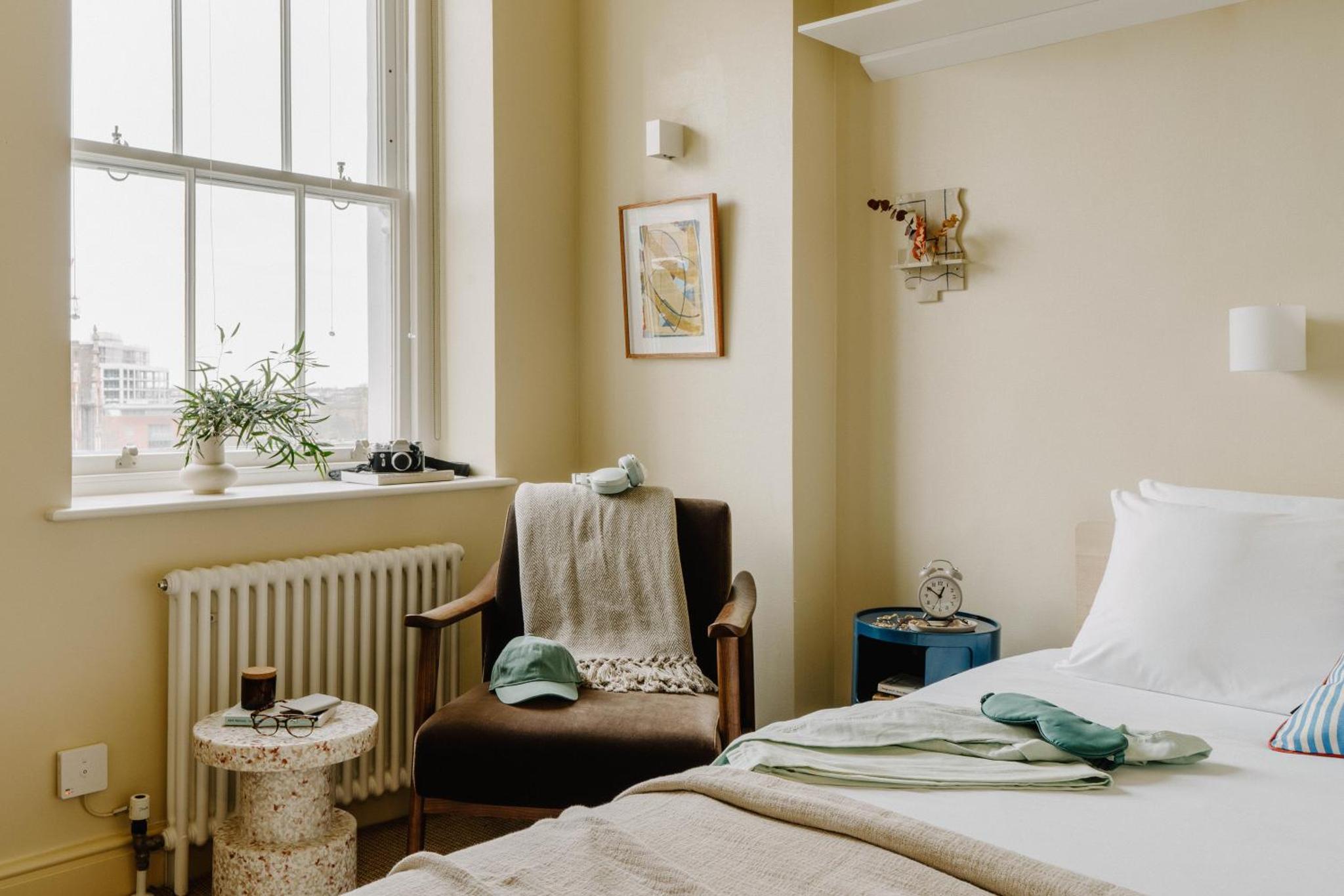 a bedroom with a bed and a chair and a window at Mason & Fifth, Primrose Hill in London