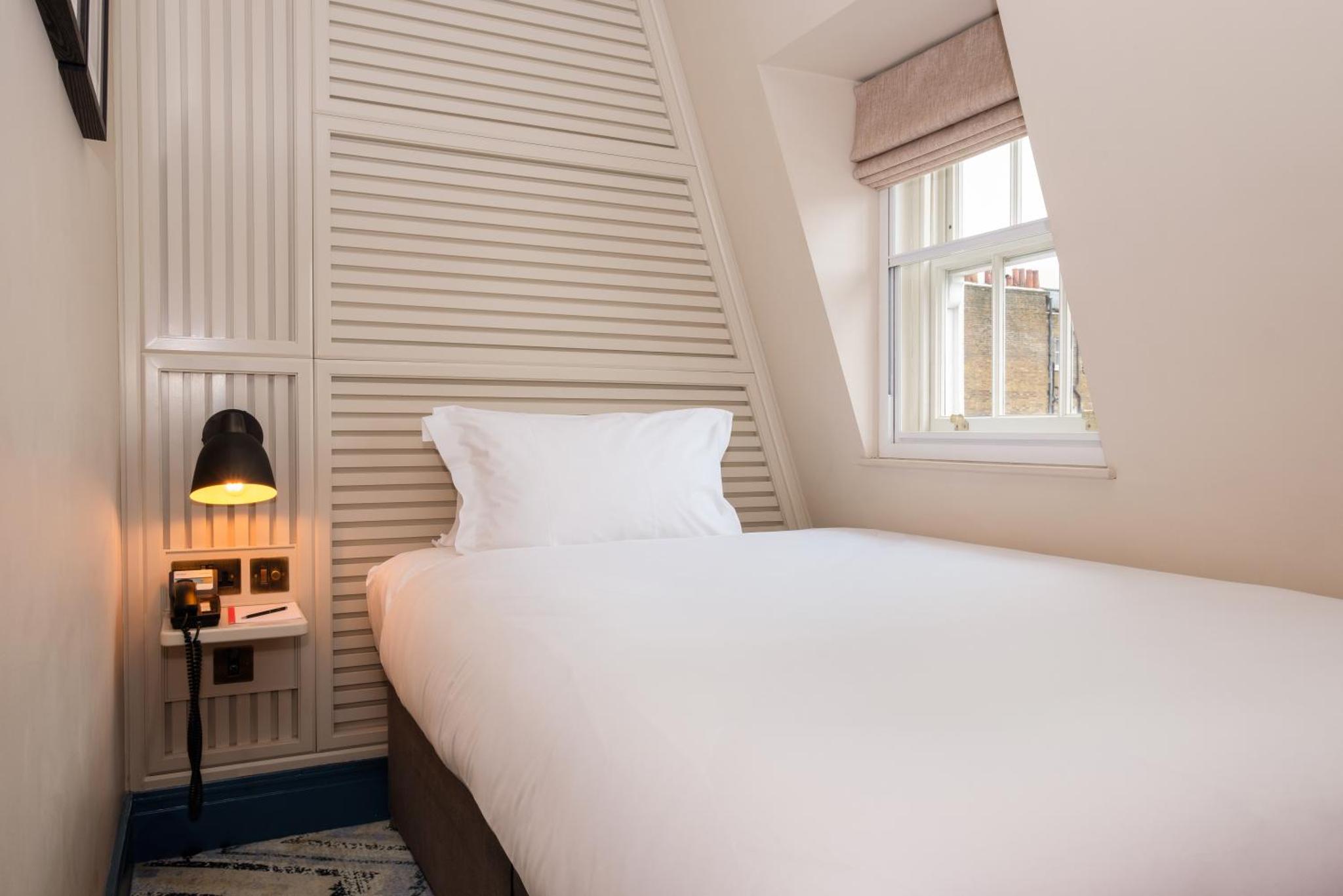 a bedroom with a white bed and a window at Home House Studio in London