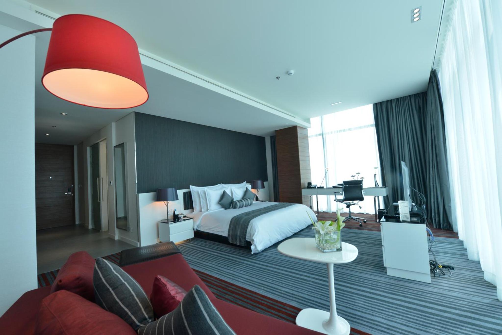 a hotel room with a bed and a couch at Ramee Grand Hotel And Spa in Manama