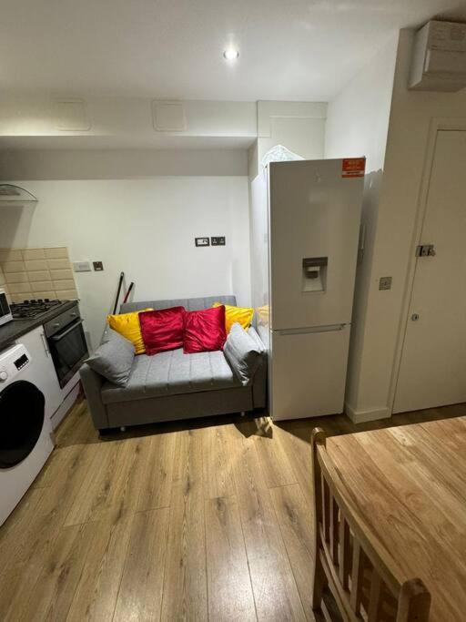 a kitchen with a couch with red and yellow pillows at Sleep 6 - 5 min from Camden Market HW5 in London