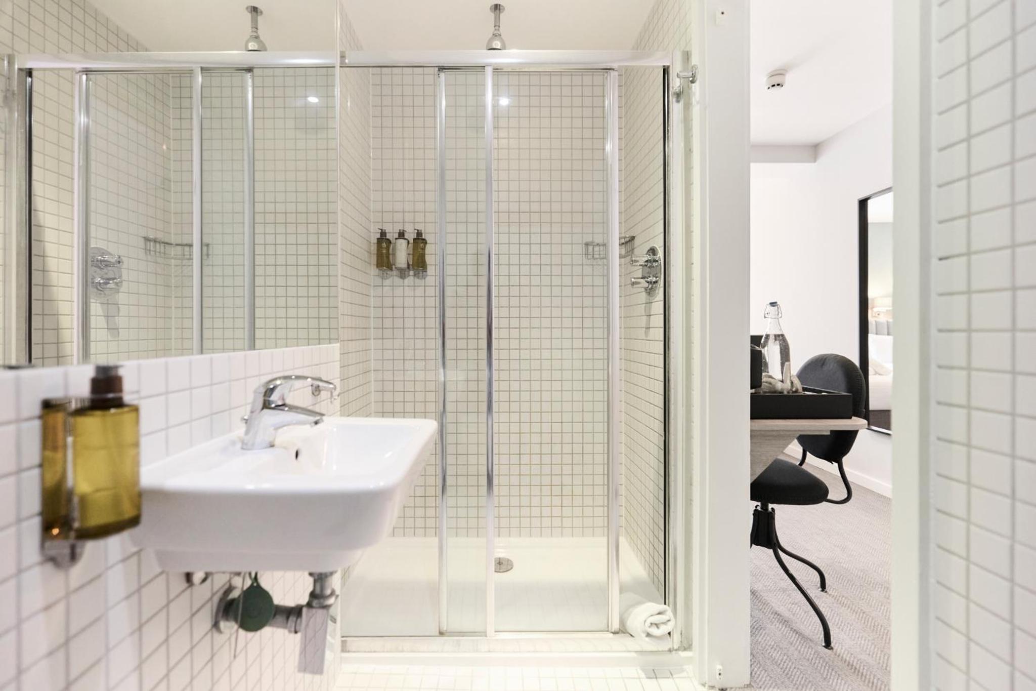 a bathroom with a sink and a shower at Prince William Hotel in London