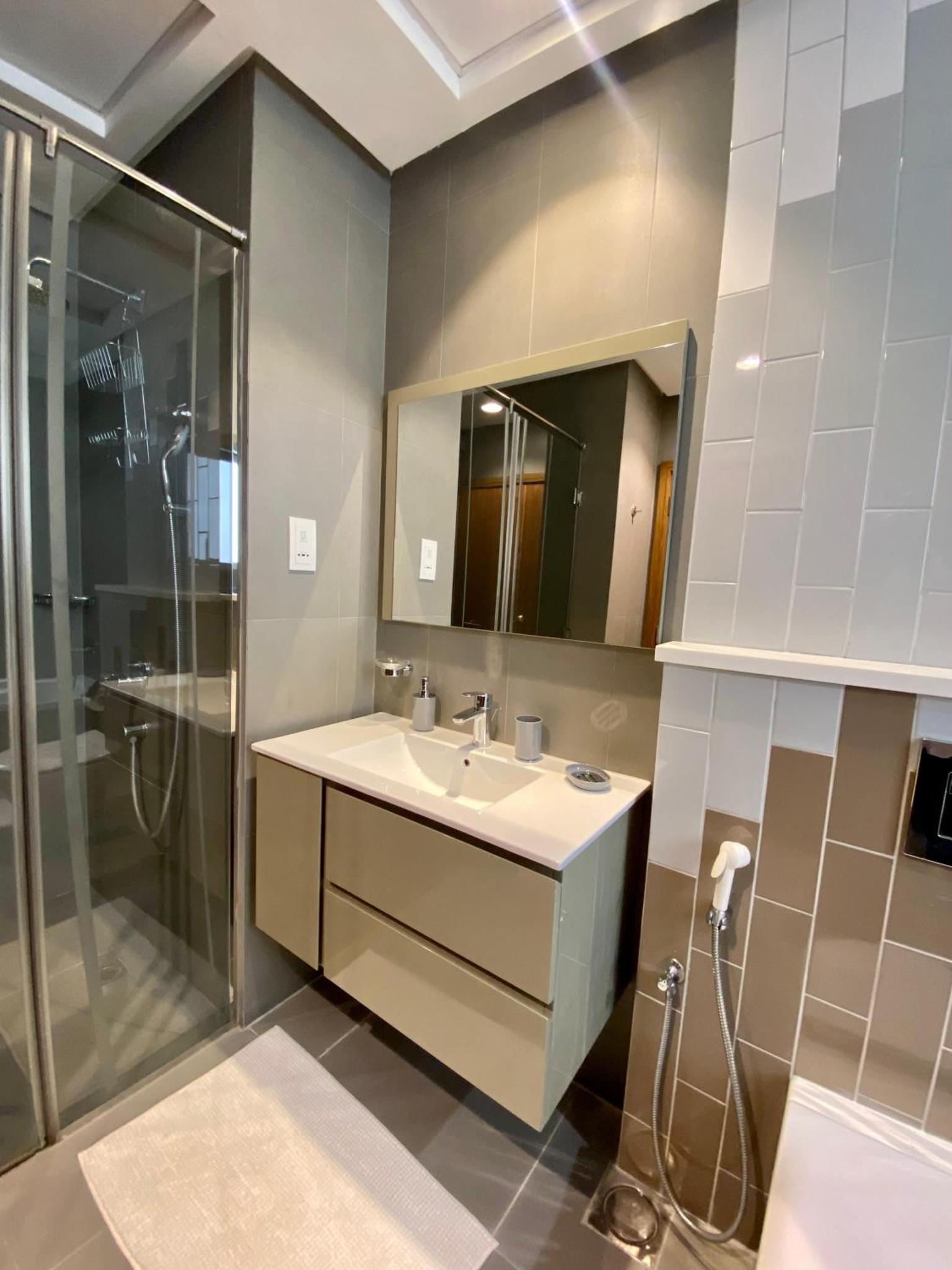 a bathroom with a sink and a shower at Seef Serenity - Sea & City Views in Manama +12 photos